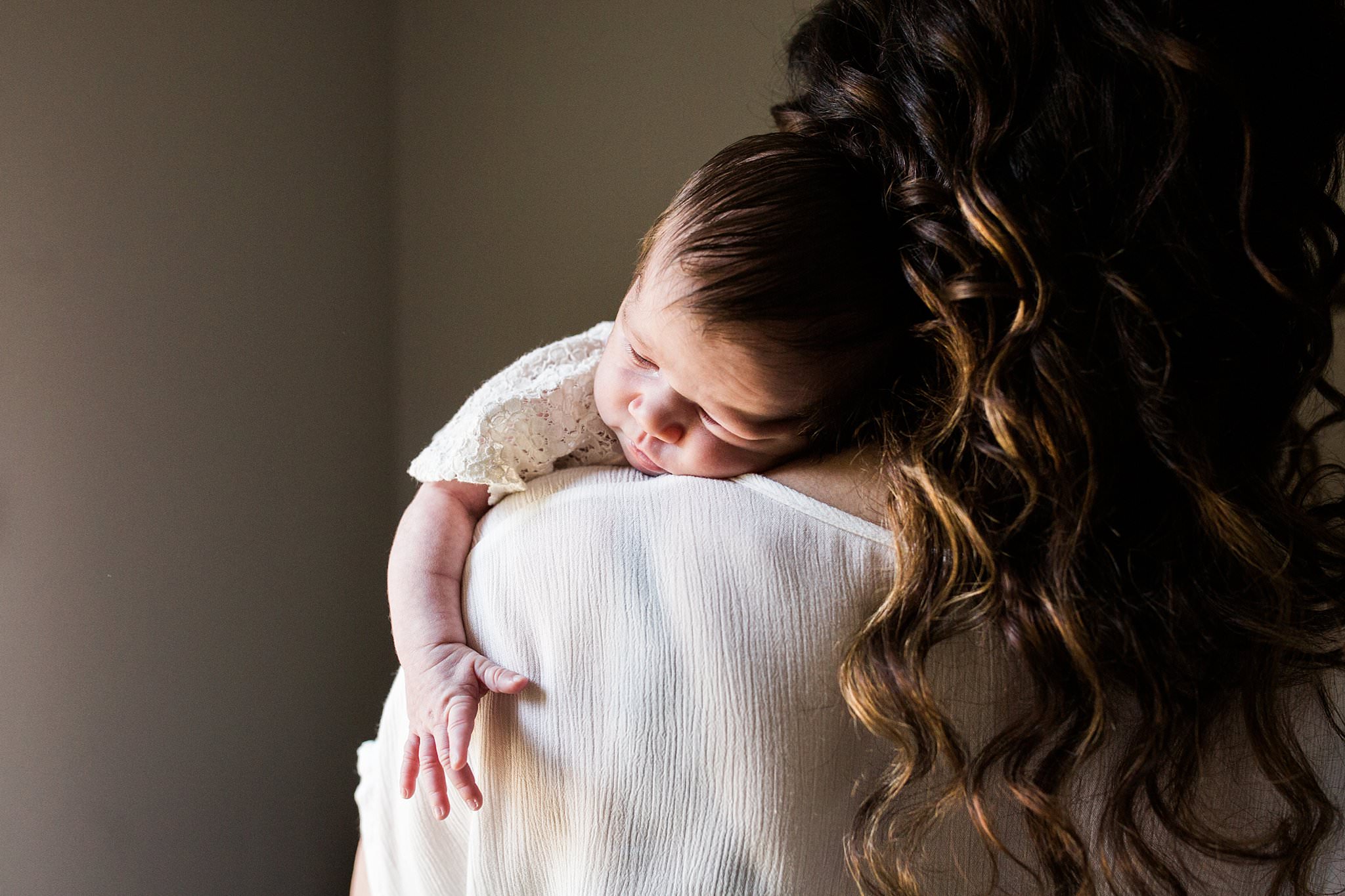 newborn on mothers shoulder