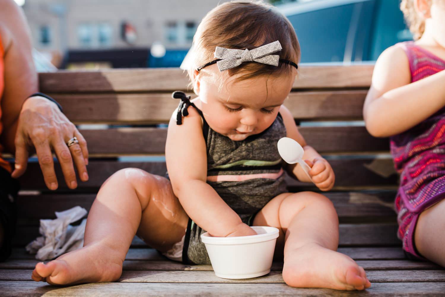 baby girl eating ice cream in adorable romper