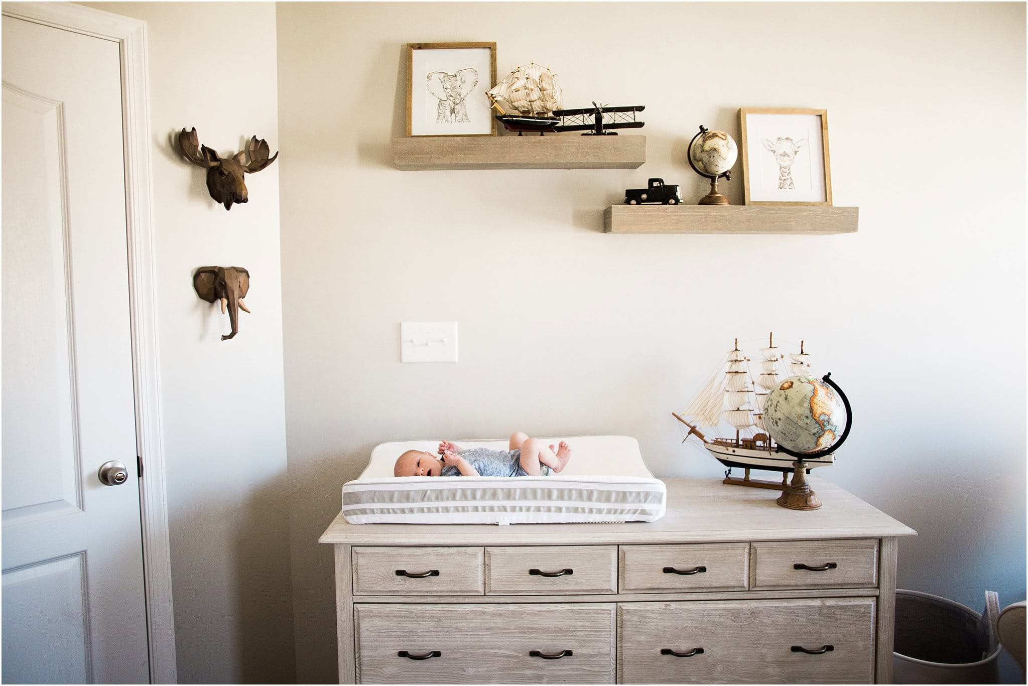 newborn boy in nursery with world travel decor