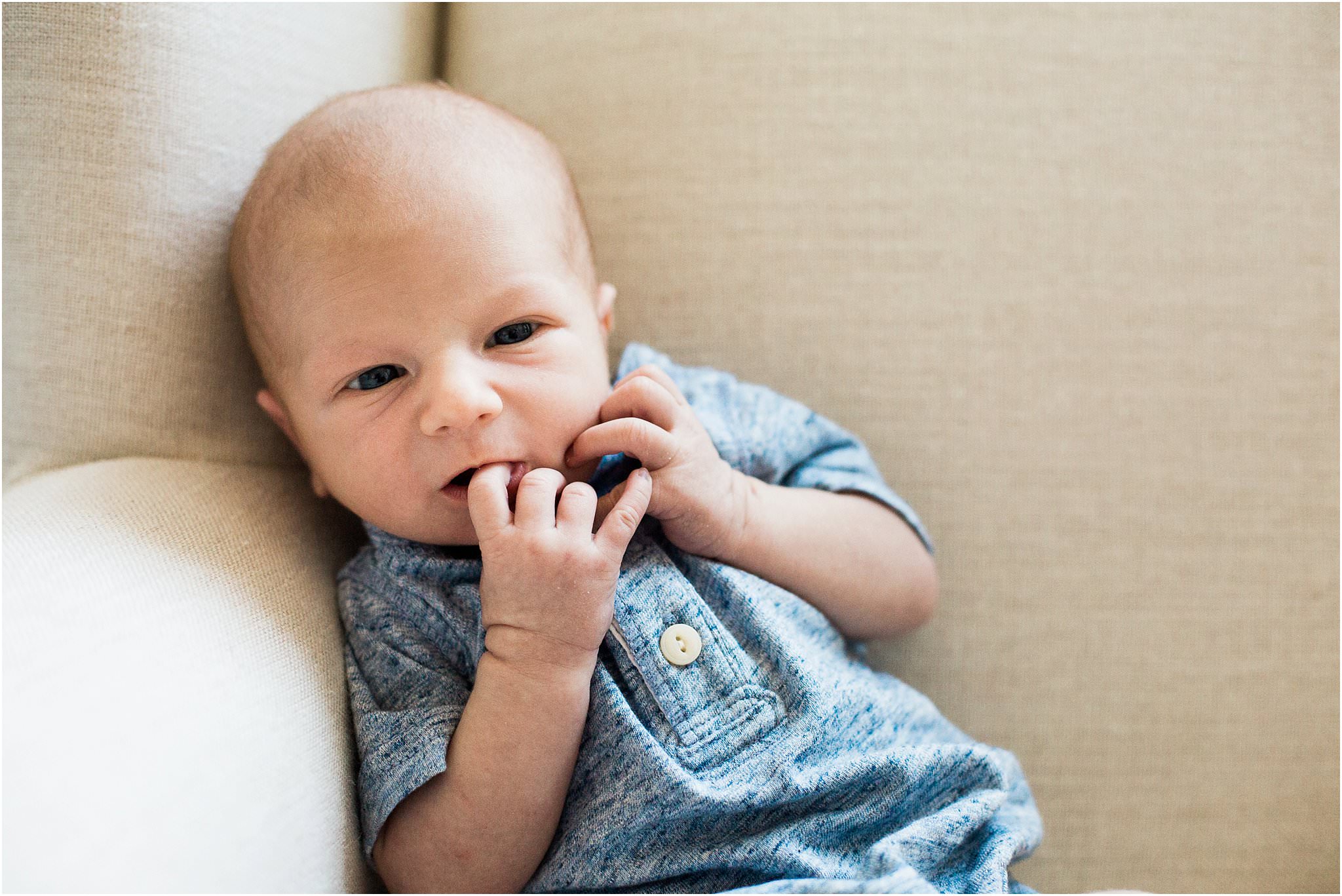 Newborn baby sitting up in nursery chair