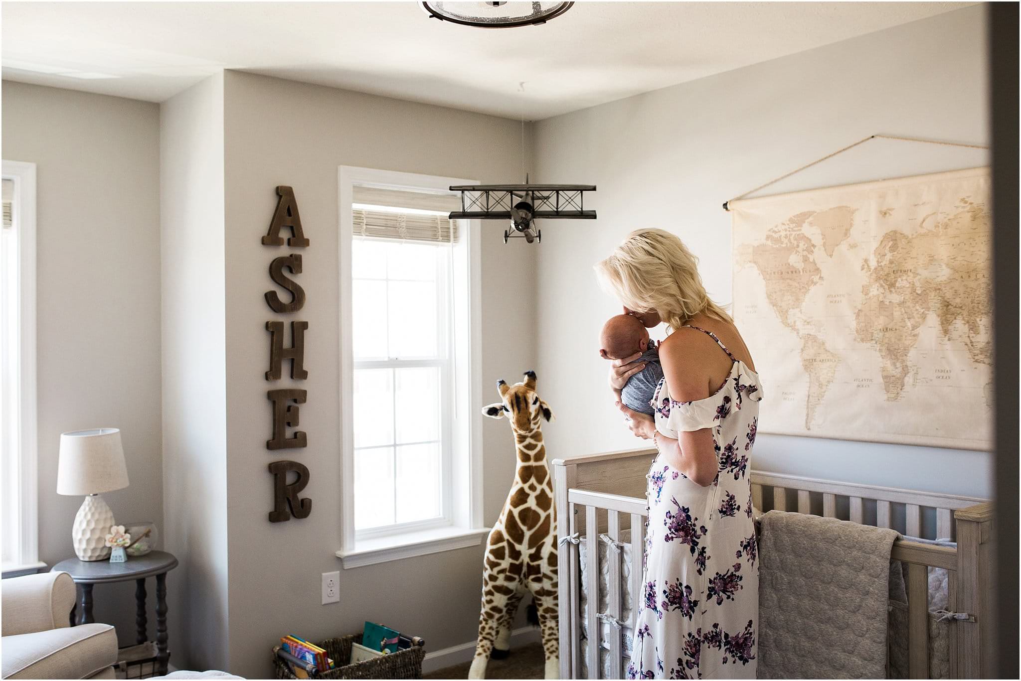 Mother holding newborn boy in nursery