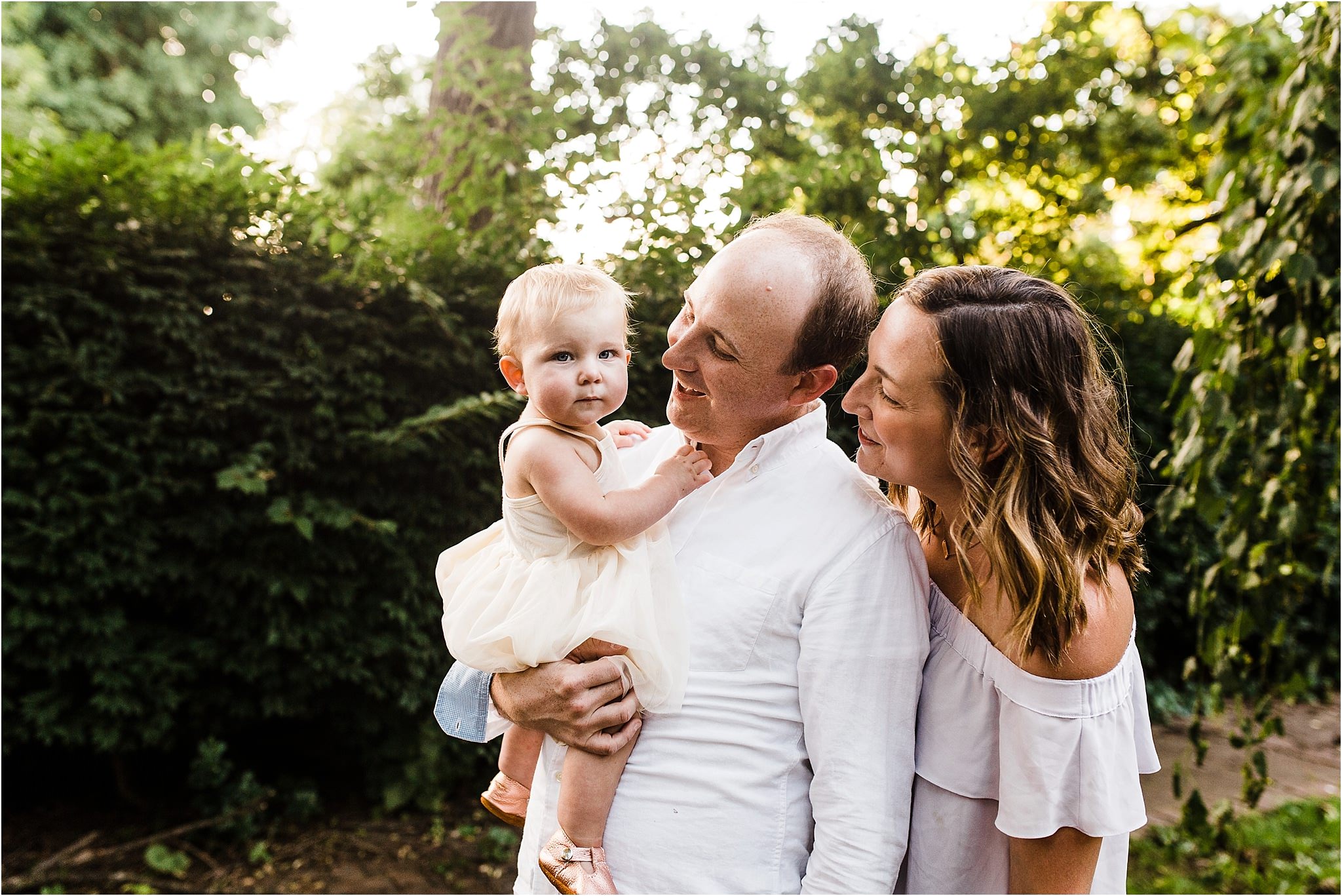 parents adoring one year old baby girl 