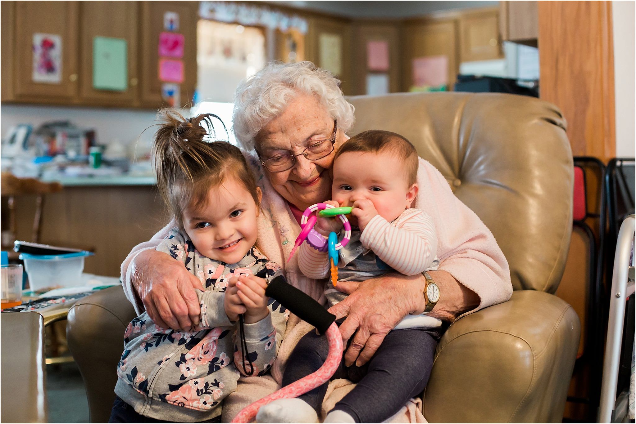 toddler and baby sister snuggling with grandma