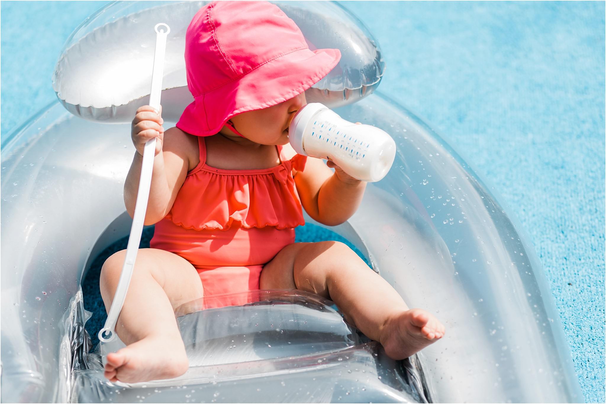 10 month old girl having a bottle at pool