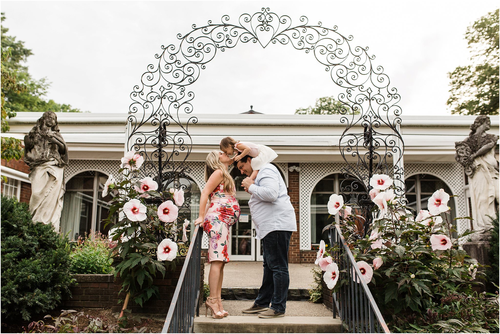 family maternity photos in floral arch