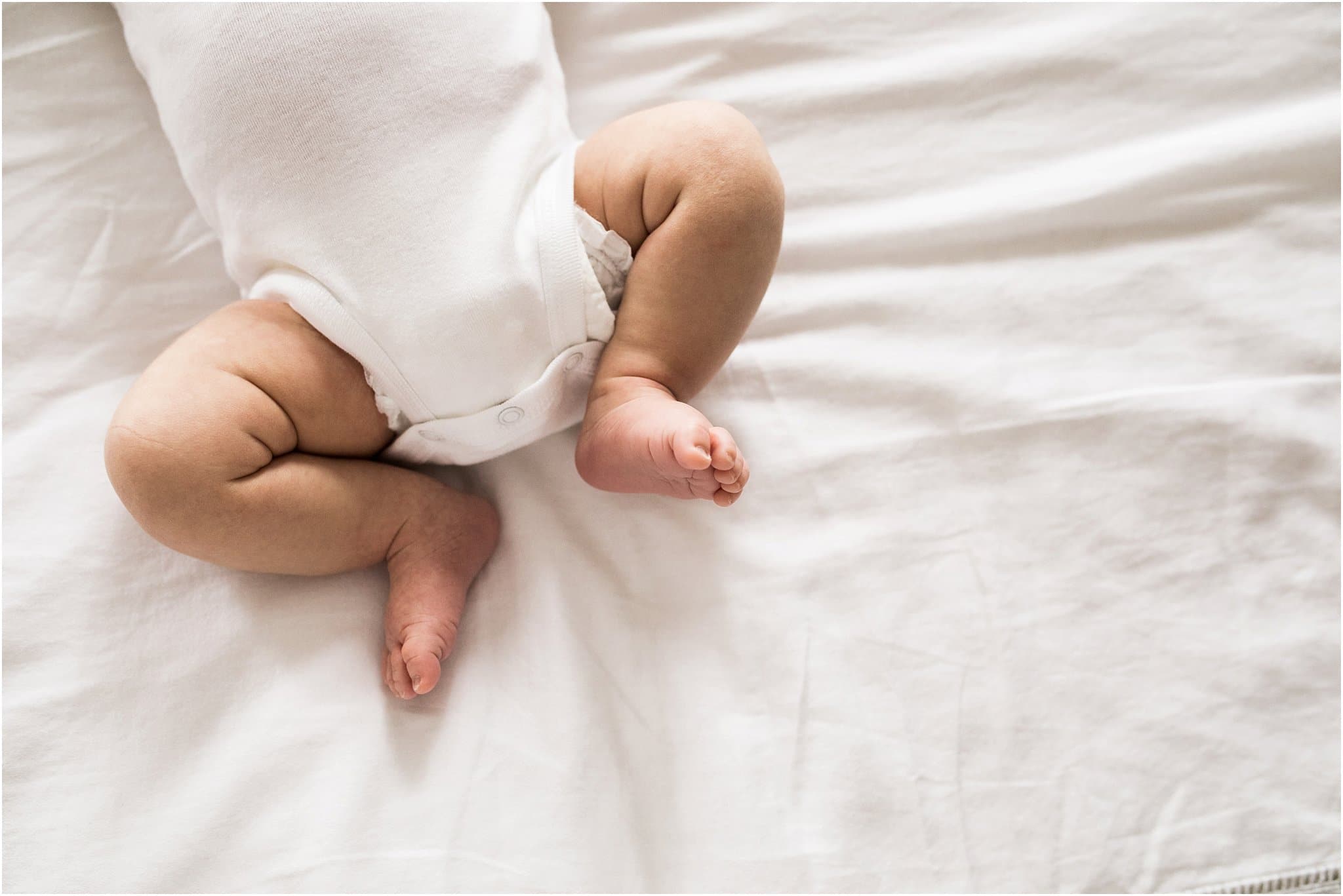 Chunky baby legs in white onesie