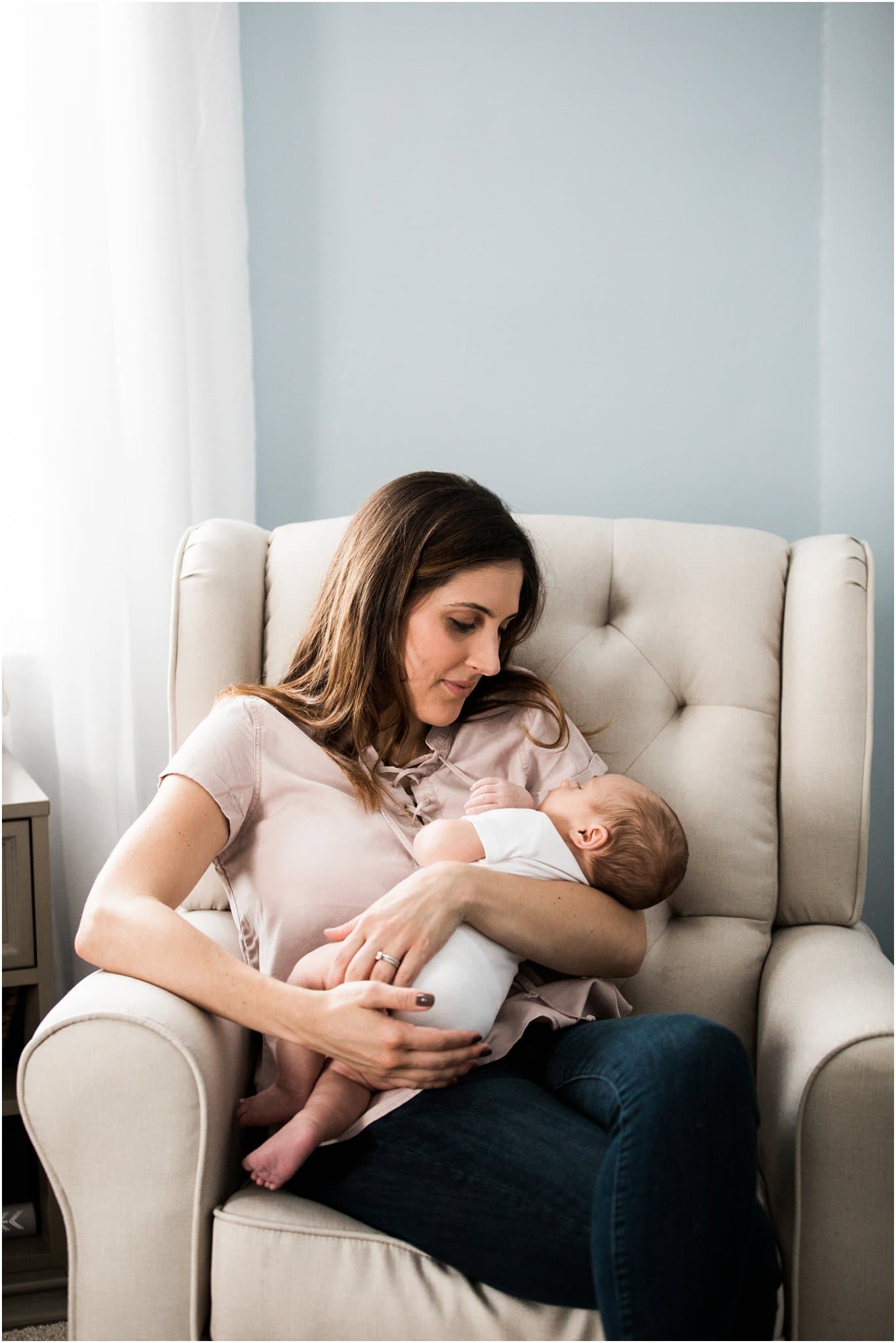 new mother holding one month old baby boy in rocker