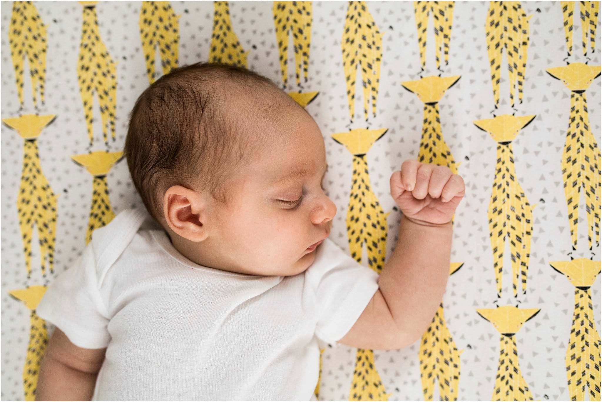 one month old baby sleeping on giraffe crib sheet