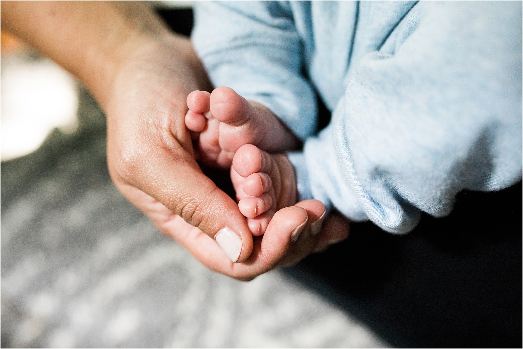 mother holding newborn baby feet