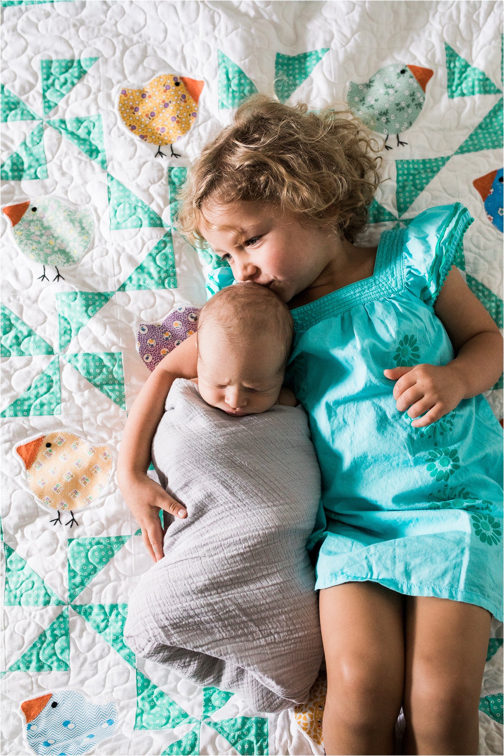 photo of big sister and new baby brother on family quilt