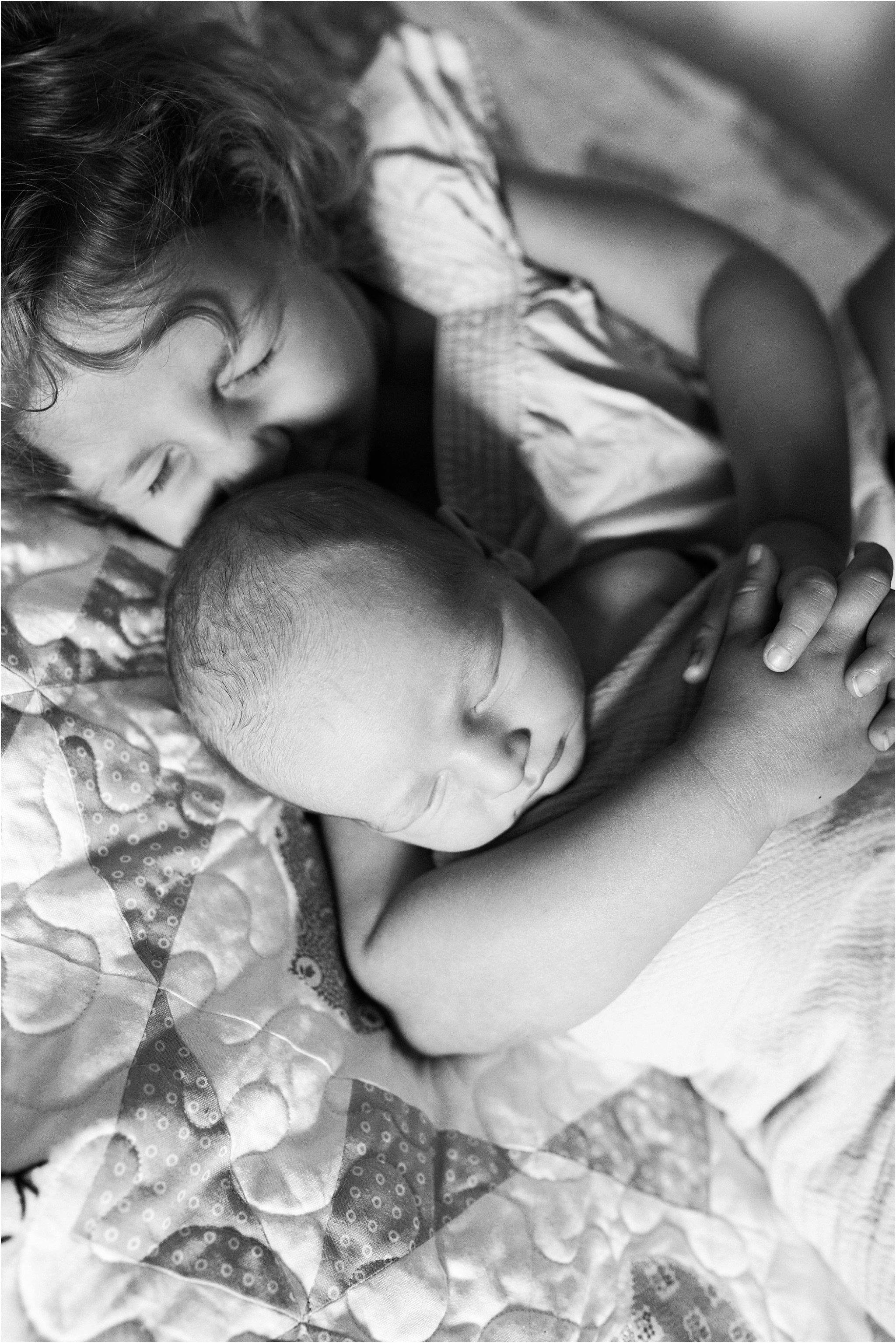 photo of big sister and new baby brother on family quilt