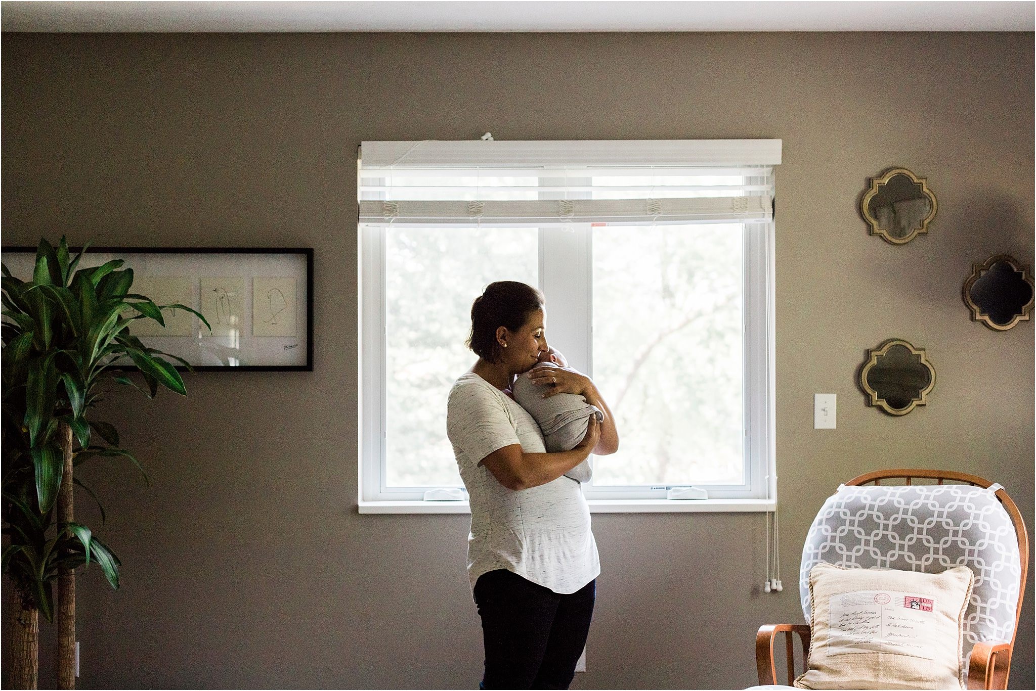 mother holding newborn in bedroom