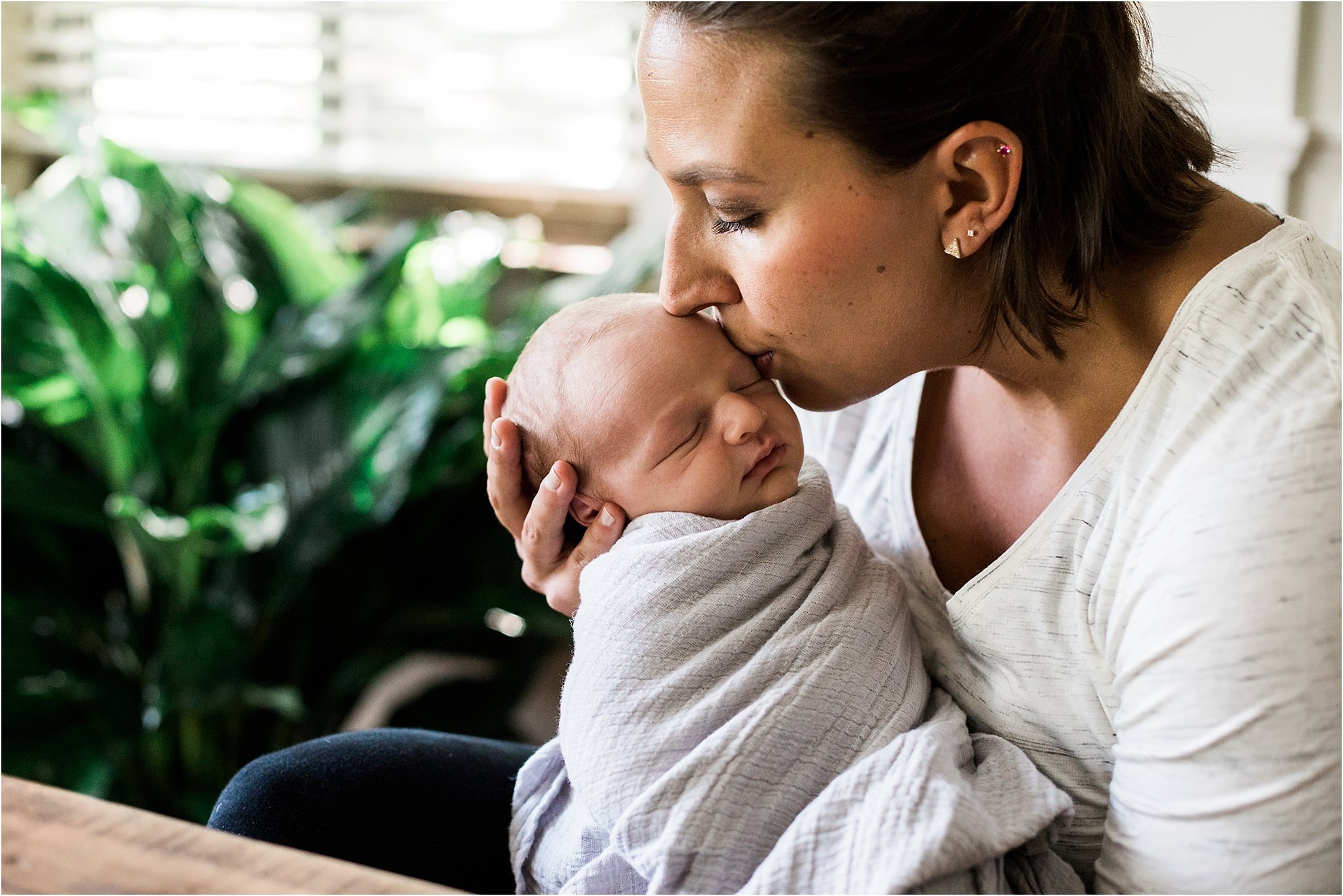 mother kissing newborn baby boy