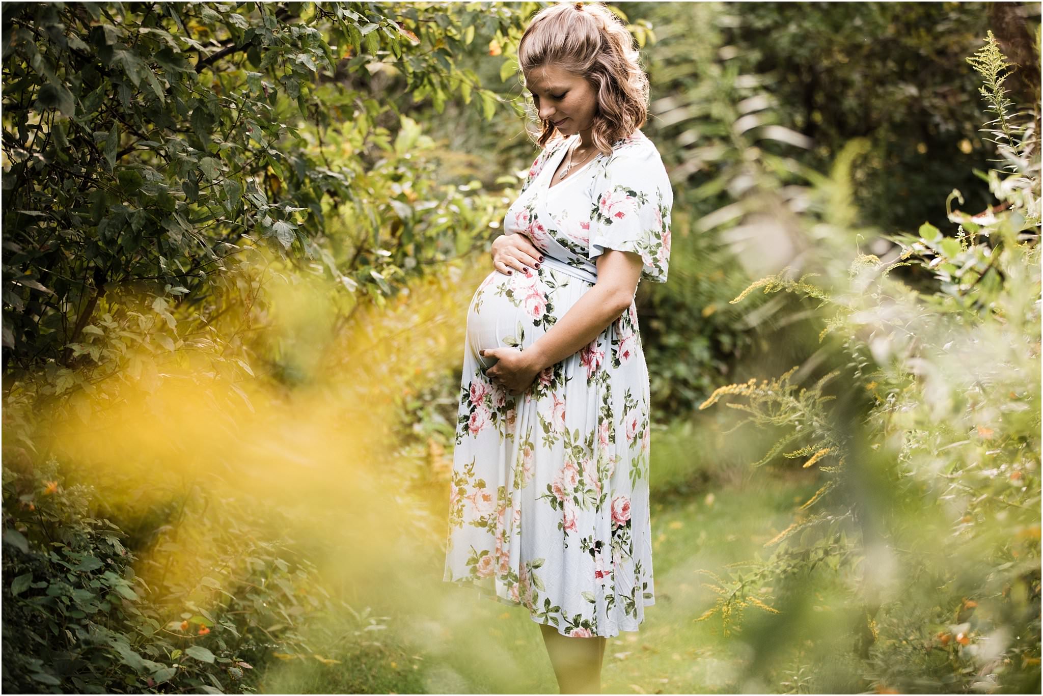 mother in flower field wearing floral maternity dress