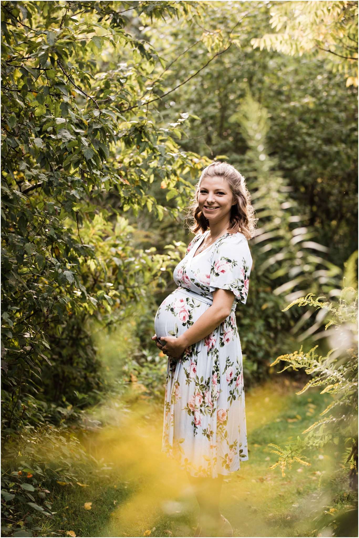 mother in flower field wearing floral maternity dress