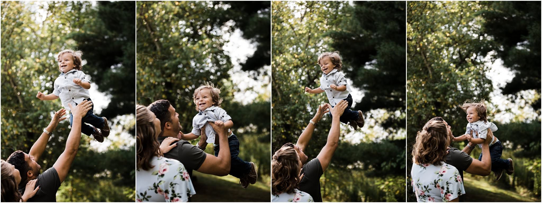 dad tossing laughing toddler boy into the air