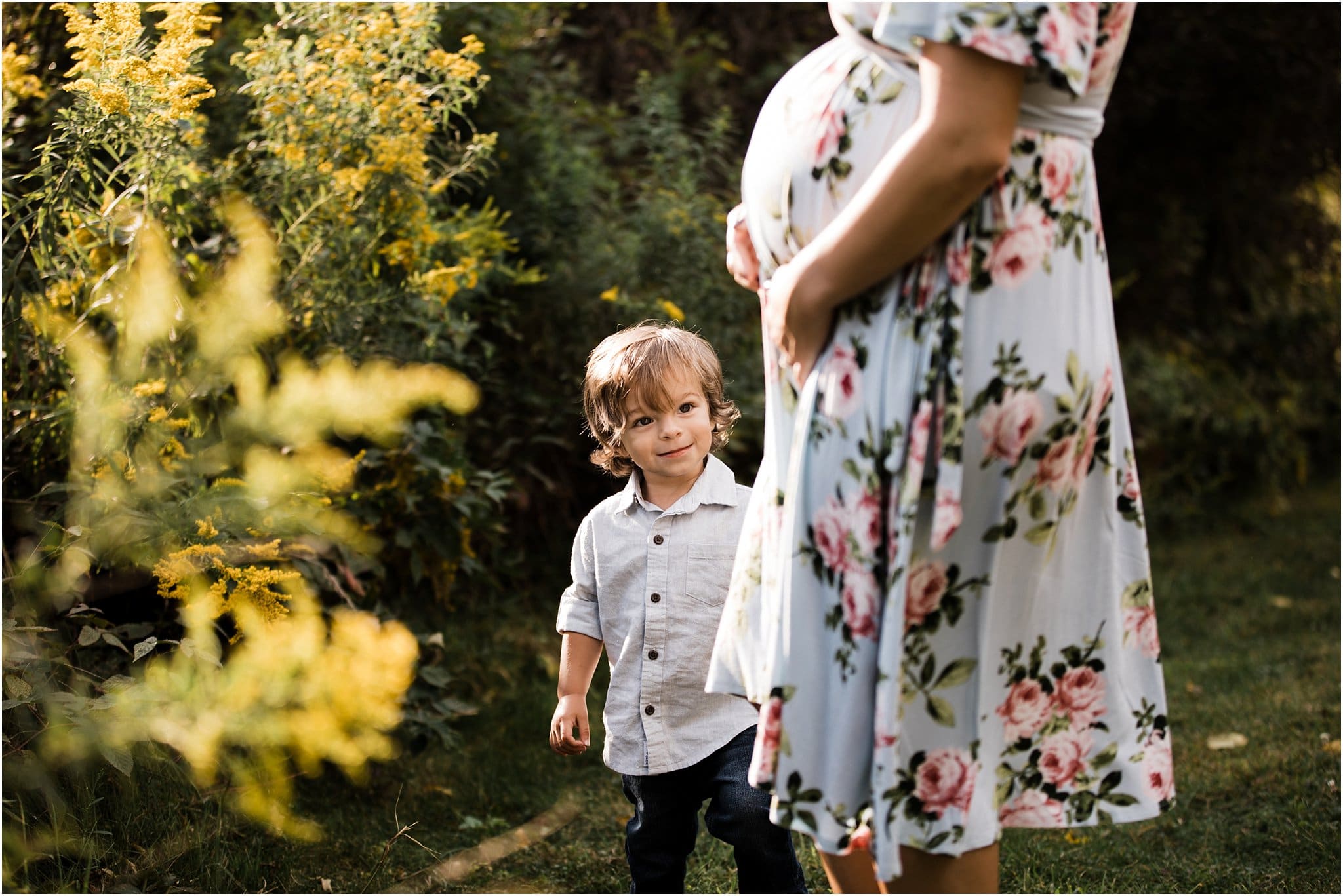 big brother looking at mothers baby bump