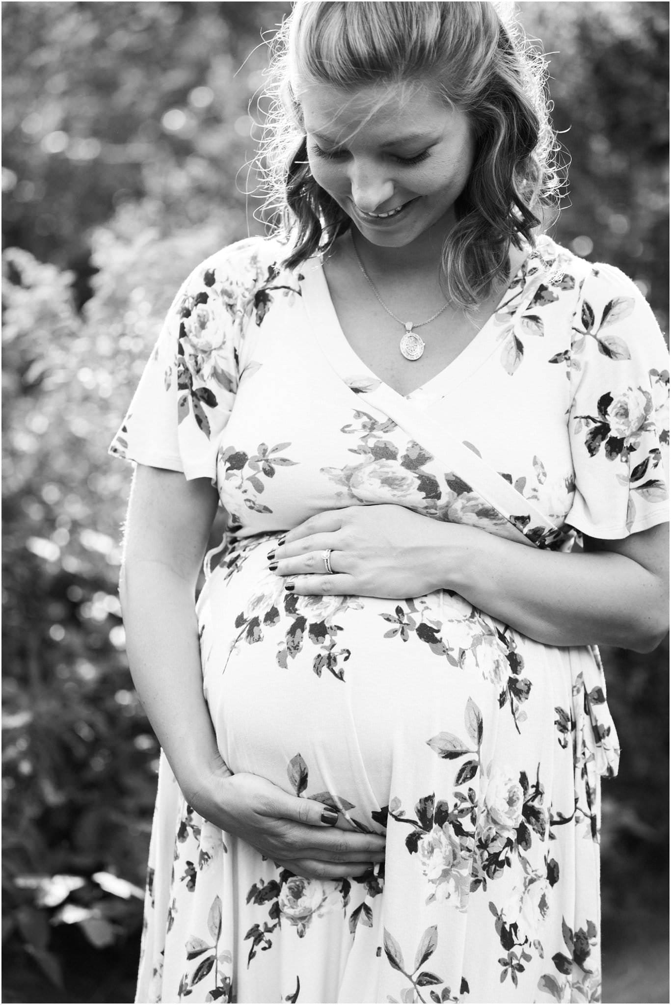 mother in flower field wearing floral maternity dress