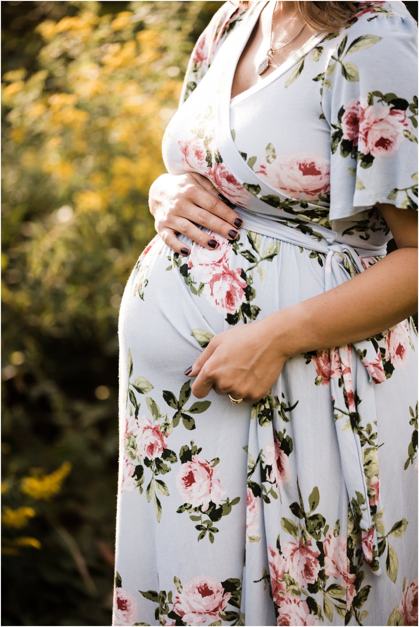 mother in flower field wearing floral maternity dress