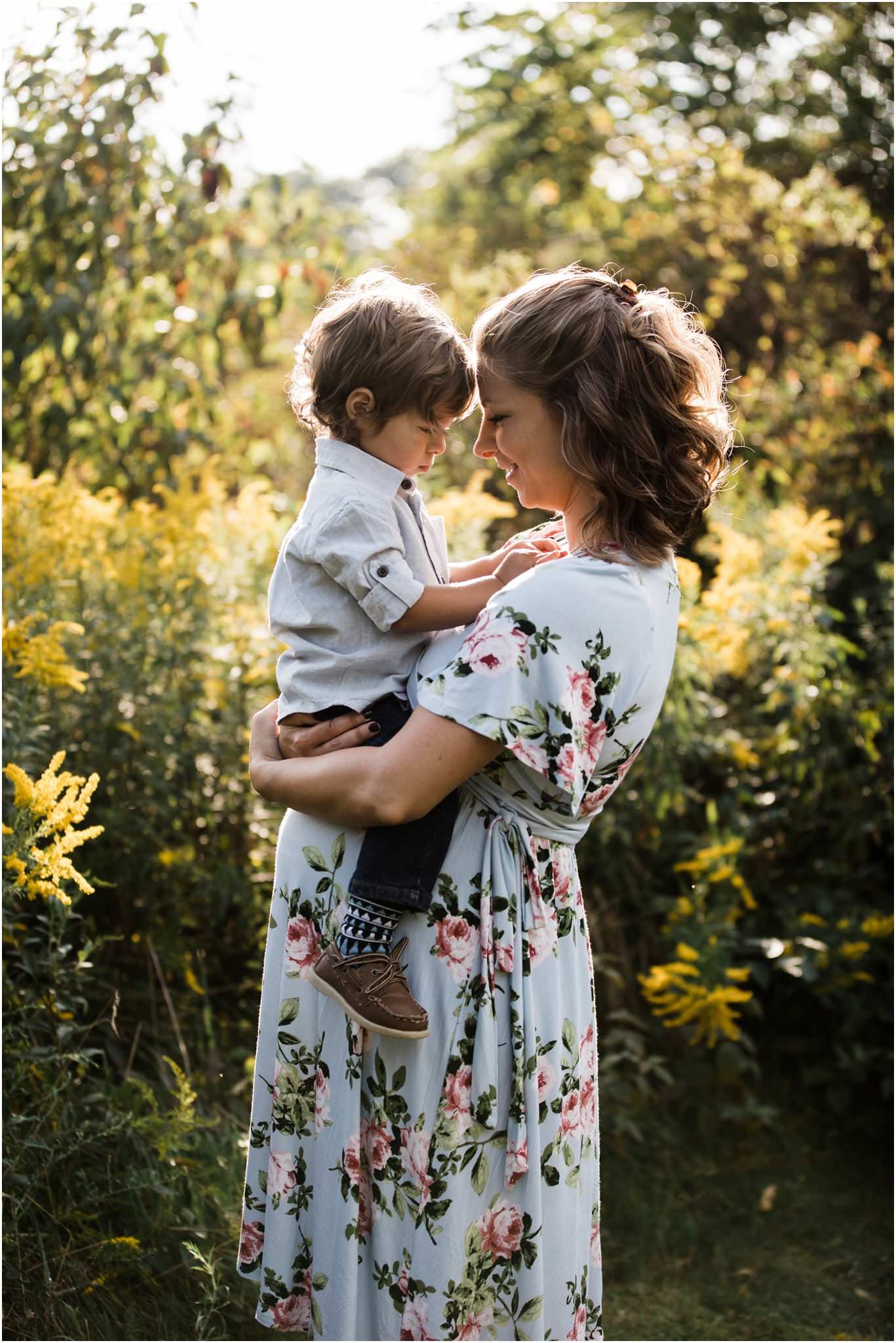 pregnant mother holding baby boy on belly