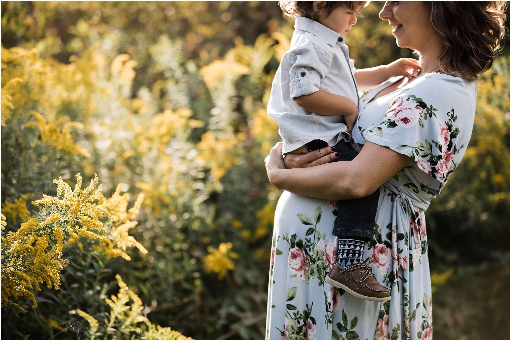 pregnant mother holding baby boy on belly