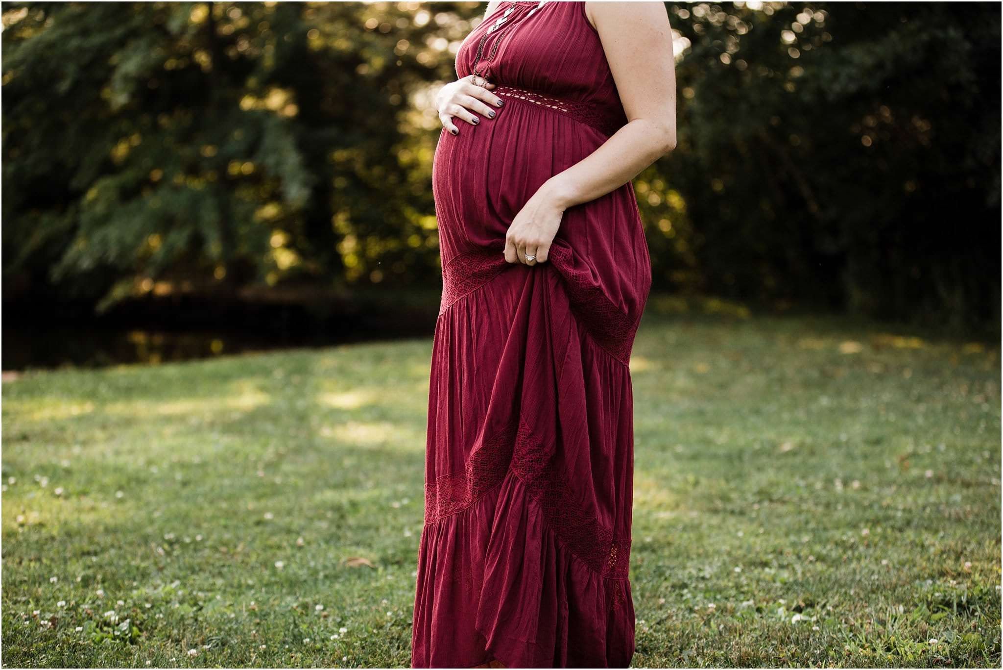 expecting mother in maroon maternity gown at golden hour