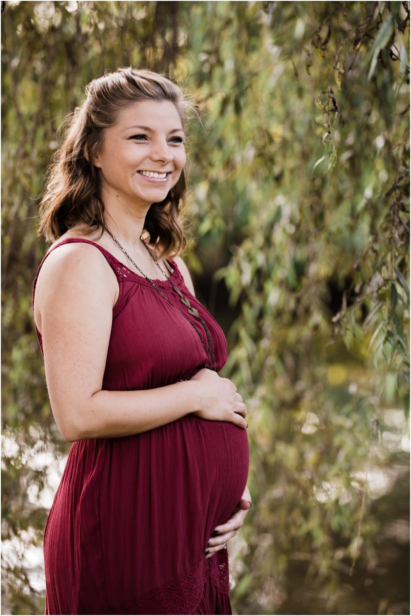 expecting mother in willow tree at golden hour