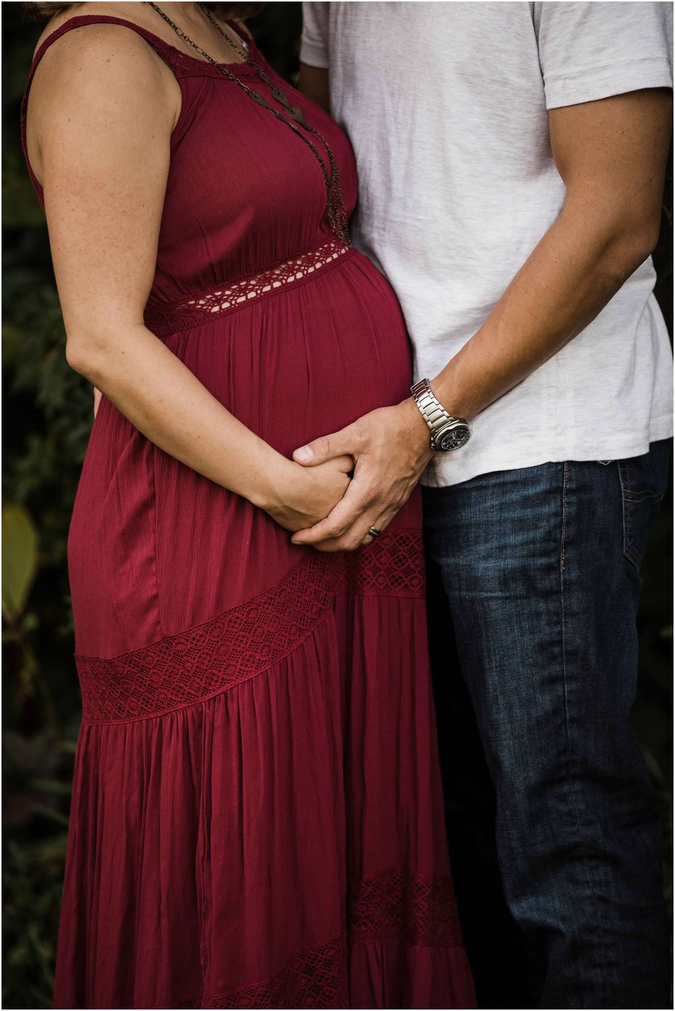 parents holding hands and baby bump