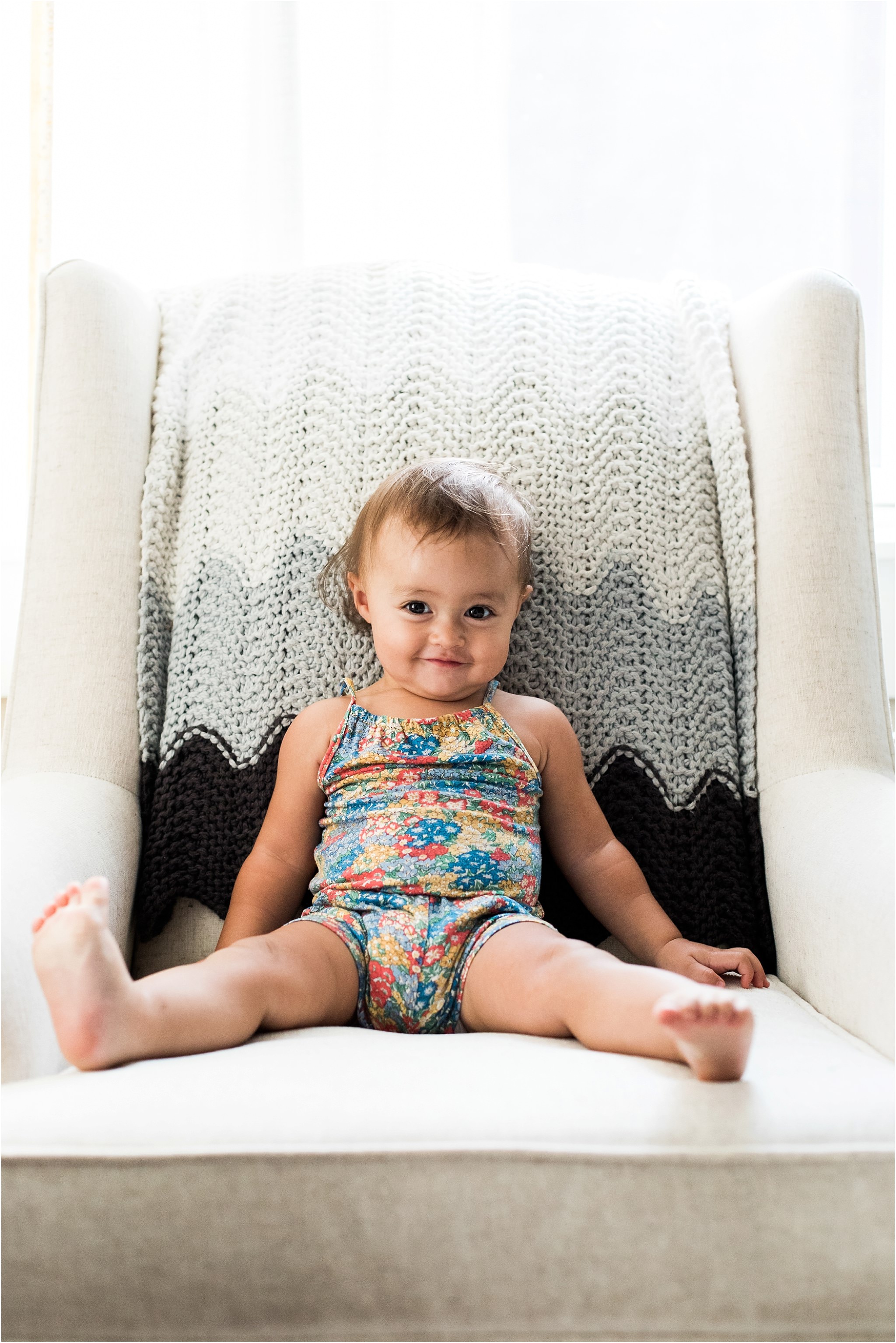 baby girl grinning on chair in her nursery