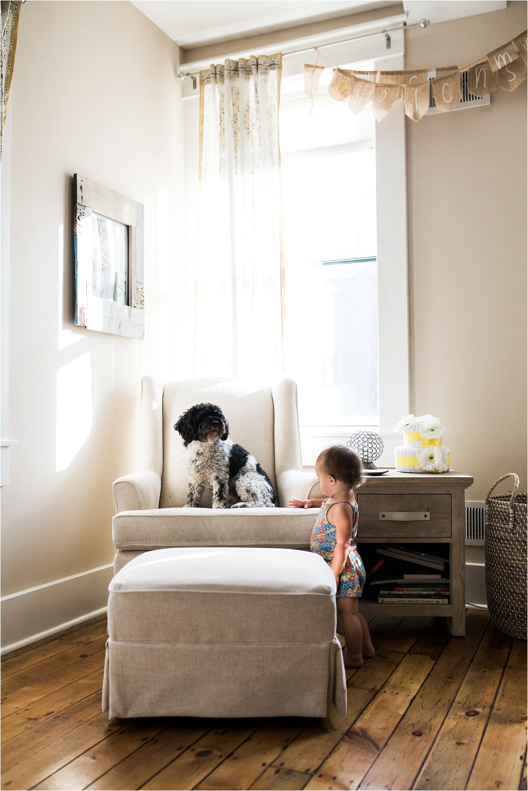 baby girl and family dog in nursery