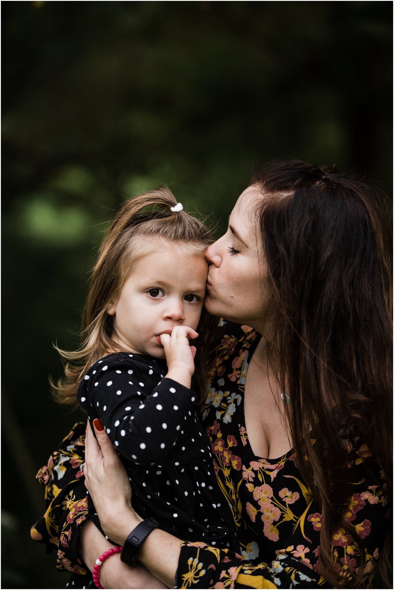 mother kissing toddler daughter