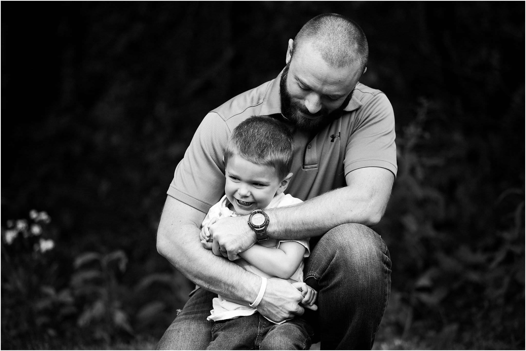 father hugging son tight and laughing