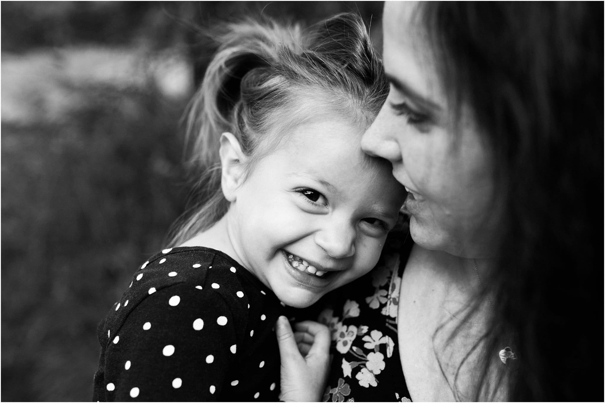 mother and daughter snuggling and smiling