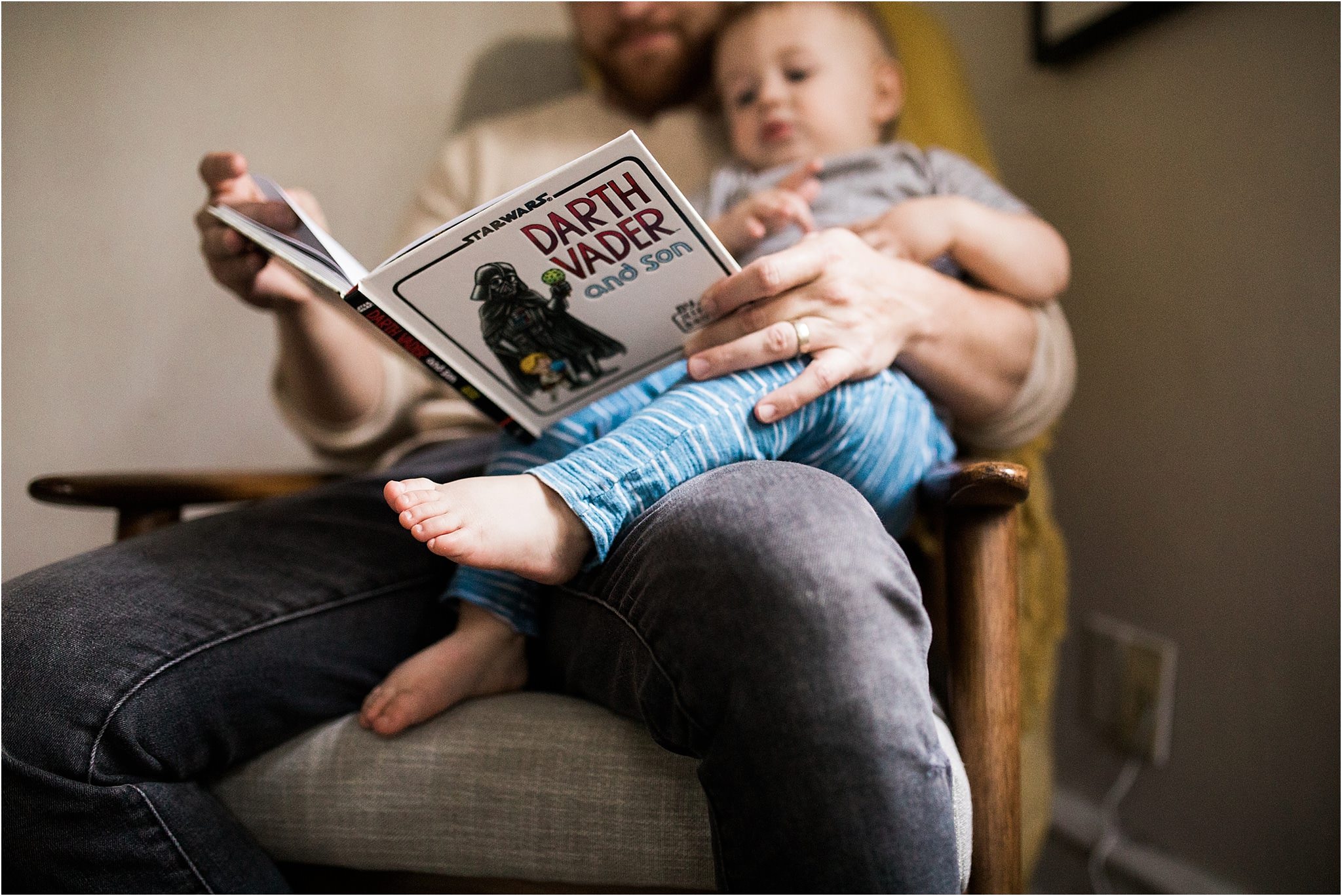 son sitting in dads lap reading