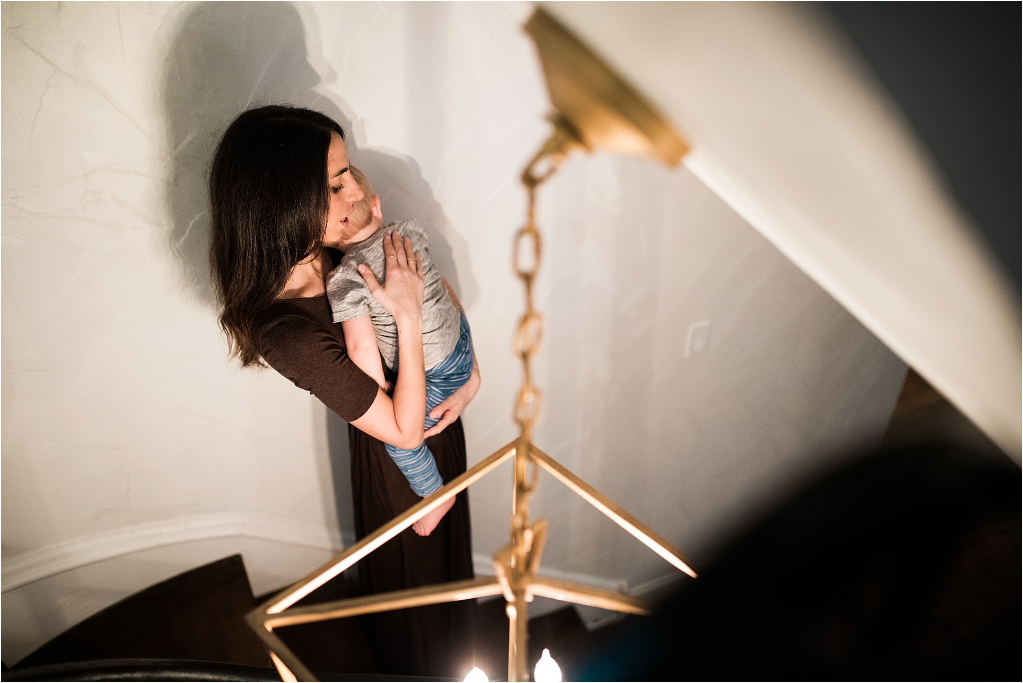 mother carrying son down stairs