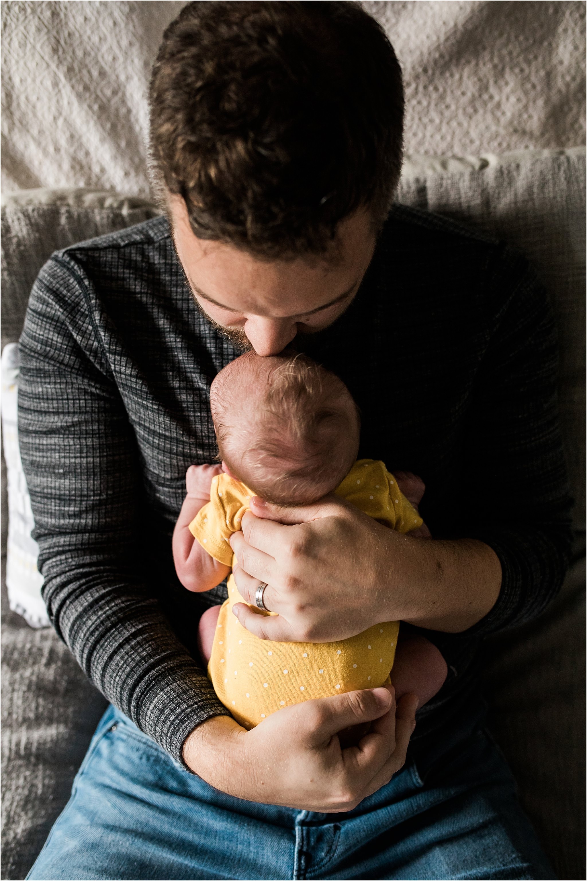 father father kissing and cuddling newborn baby in his arms