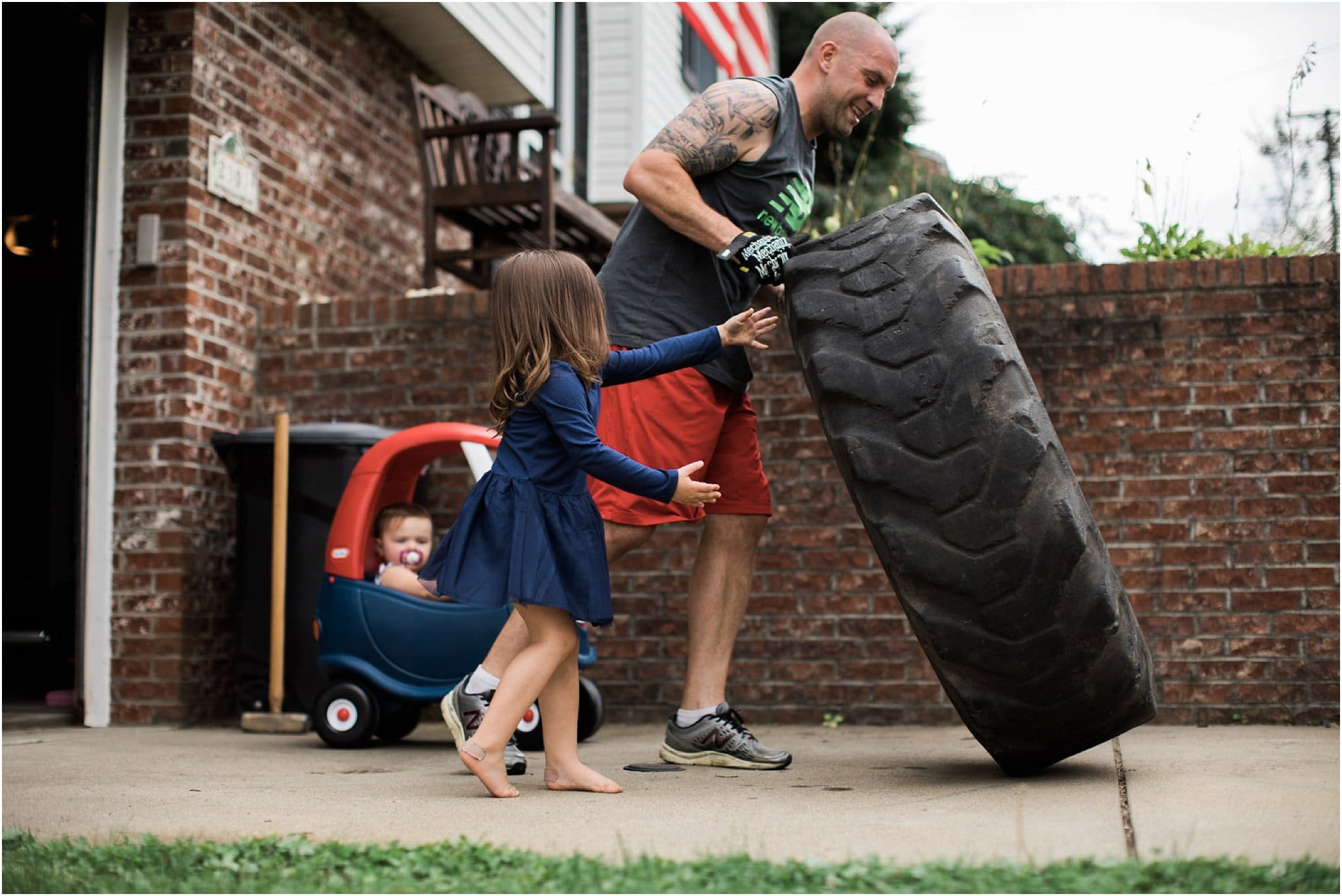 daughters working out with father flipping a tire