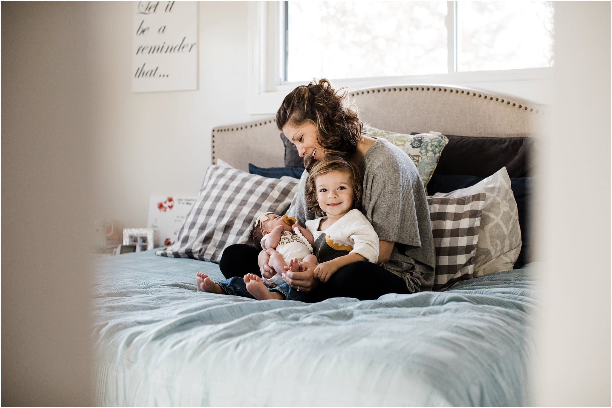 mother holding toddler boy and newborn baby girl