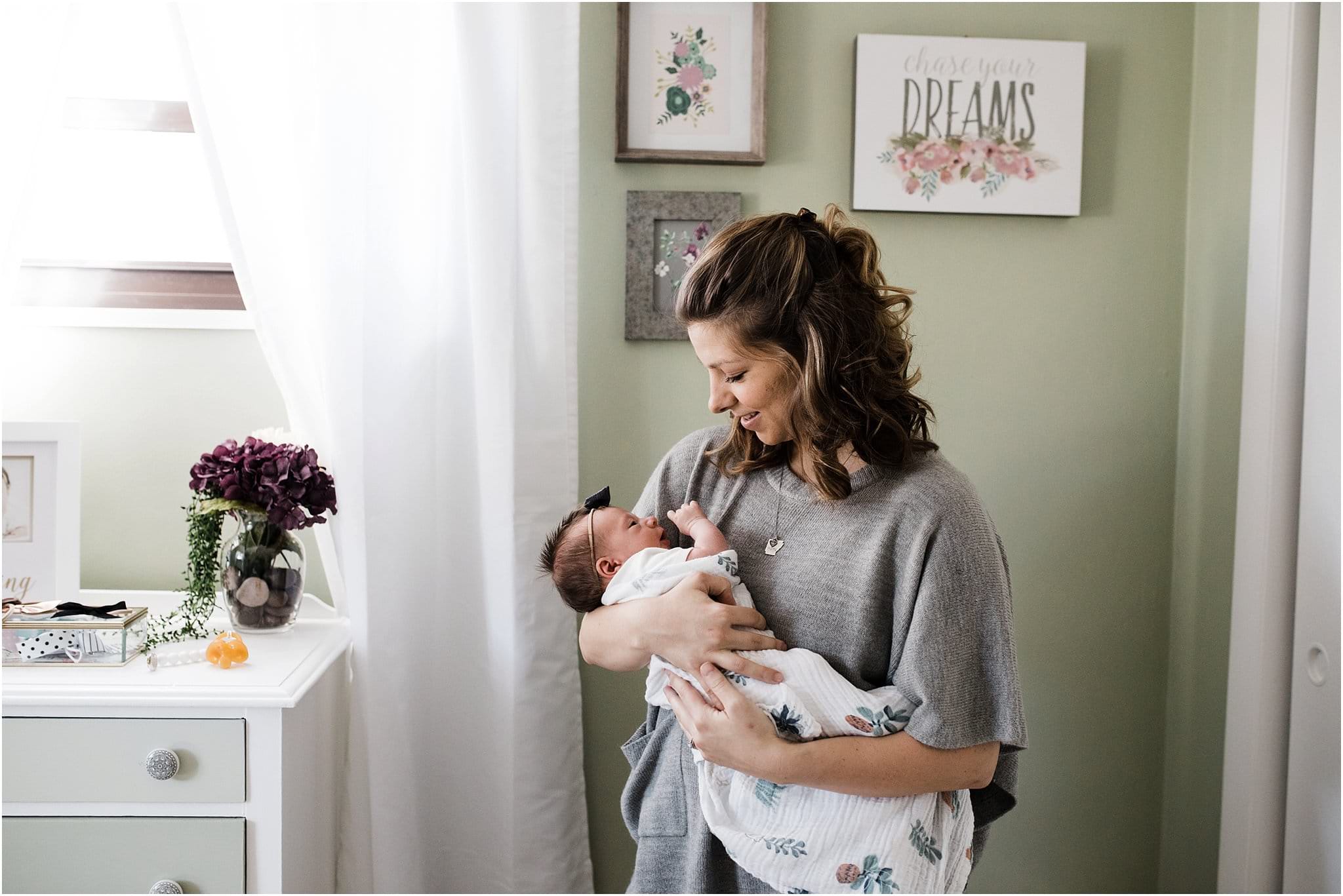 mother holding and kissing newborn baby girl