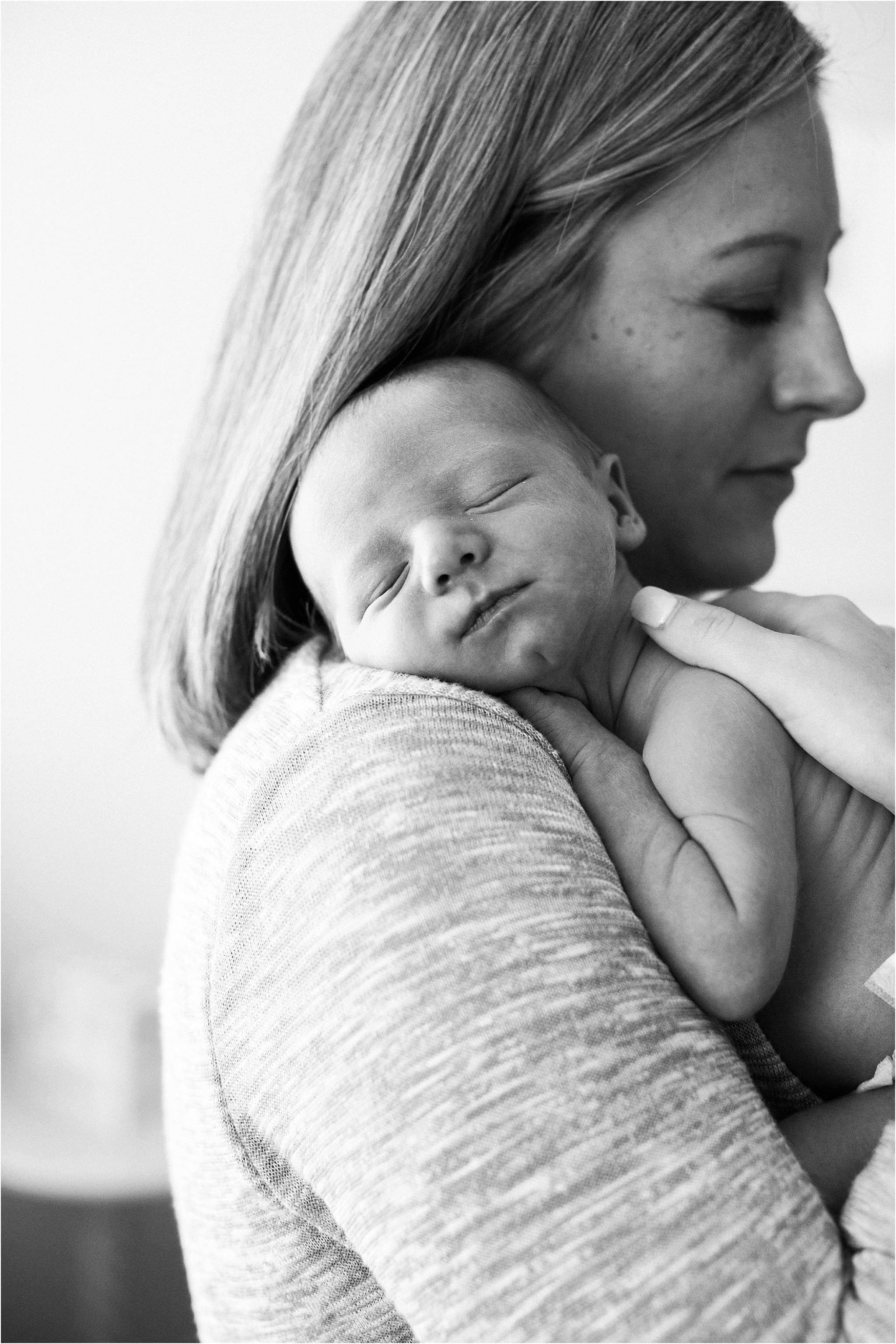 newborn resting on mothers shoulder