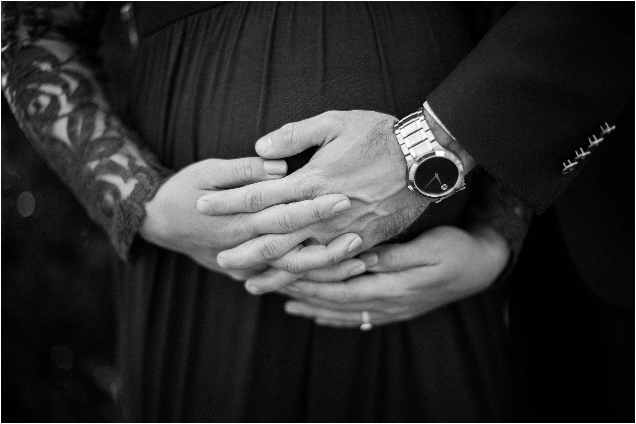 parent hand interlocked over baby bump