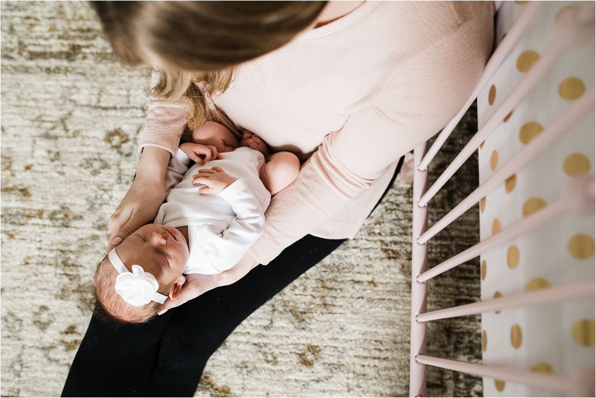 mother gazing at newborn girl in home nursery