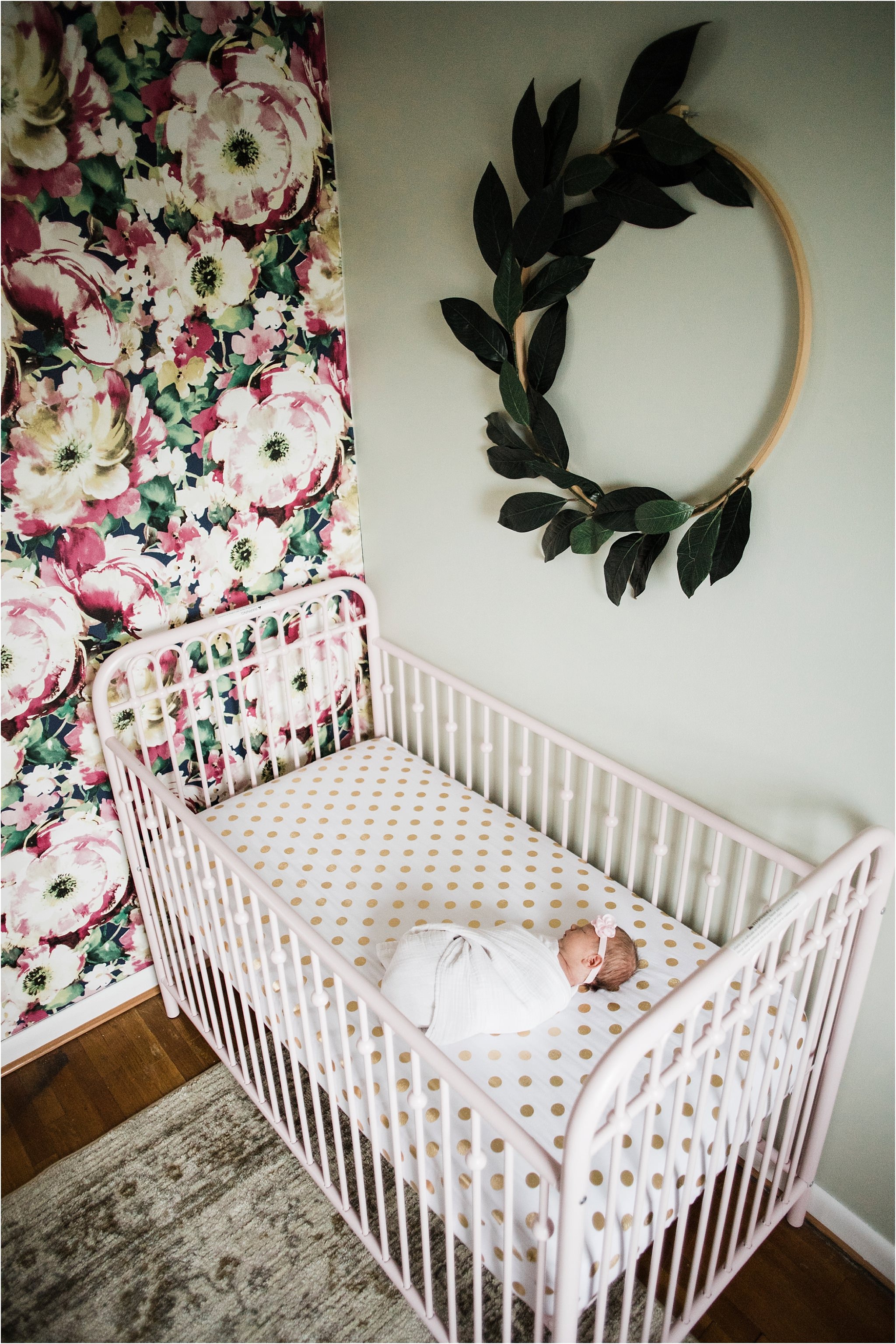 newborn girl swaddled in pink crib 