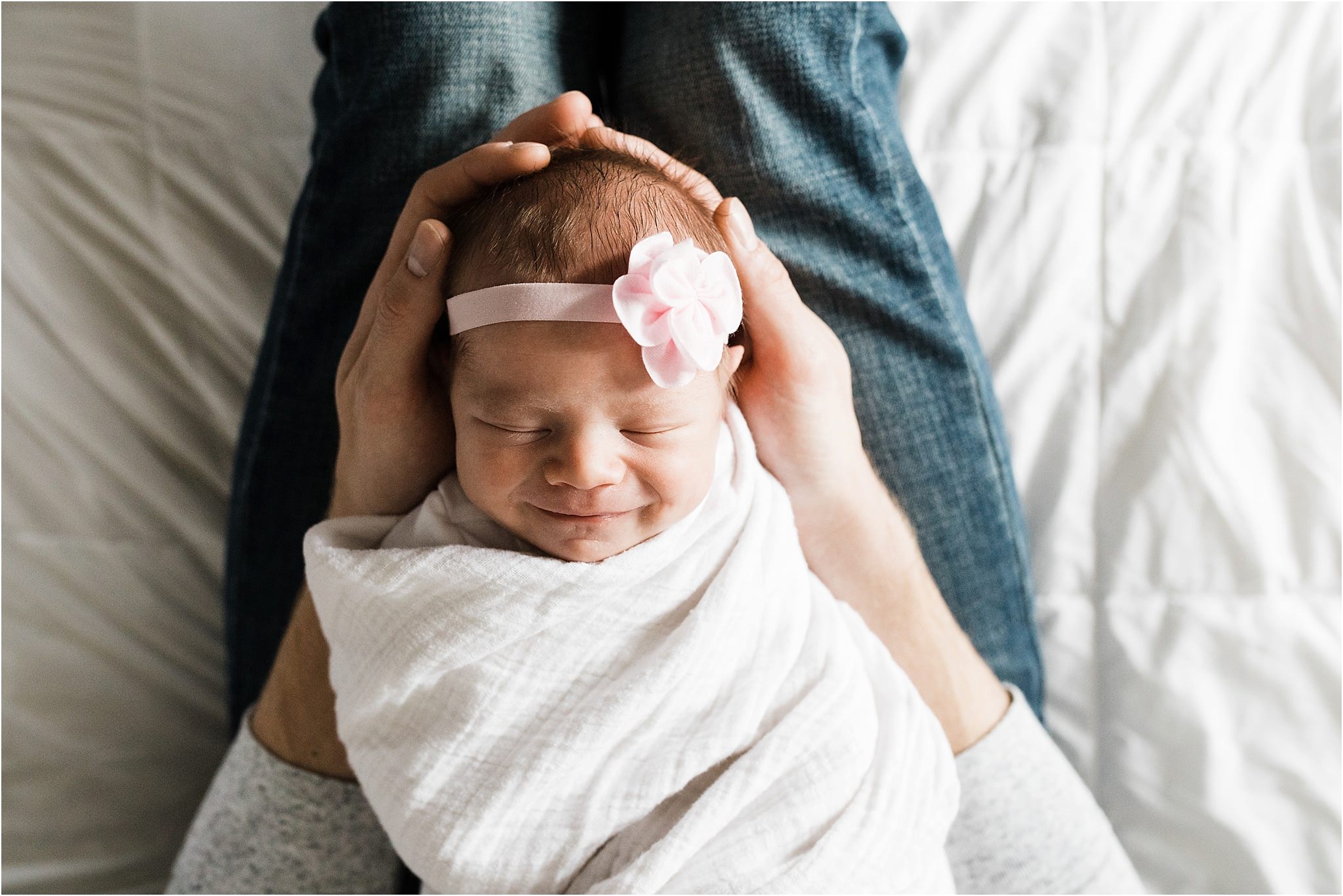 smiling newborn baby girl in daddys arms