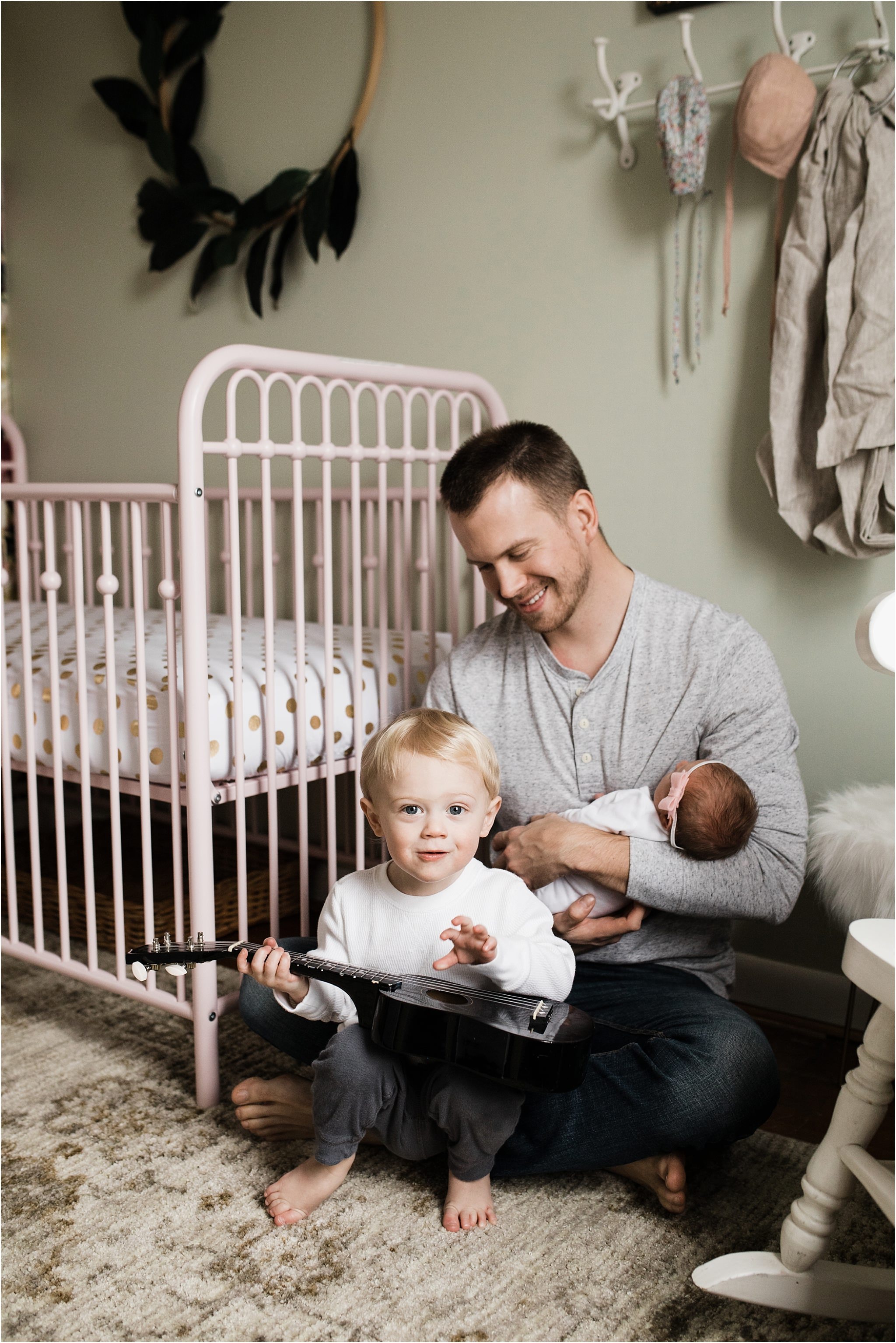 brother singing and playing guitar for new baby sister