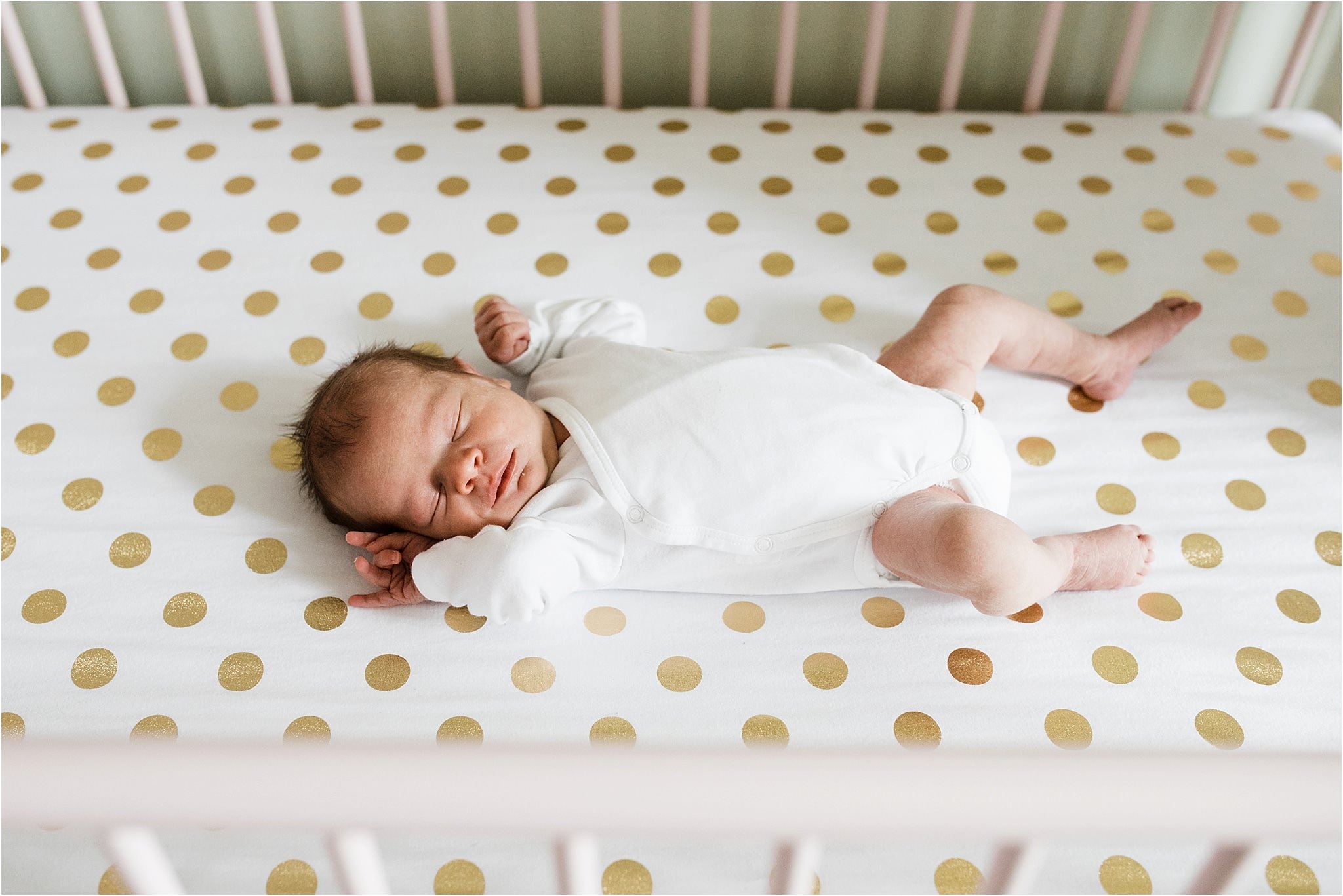 newborn in simple white onesie in crib