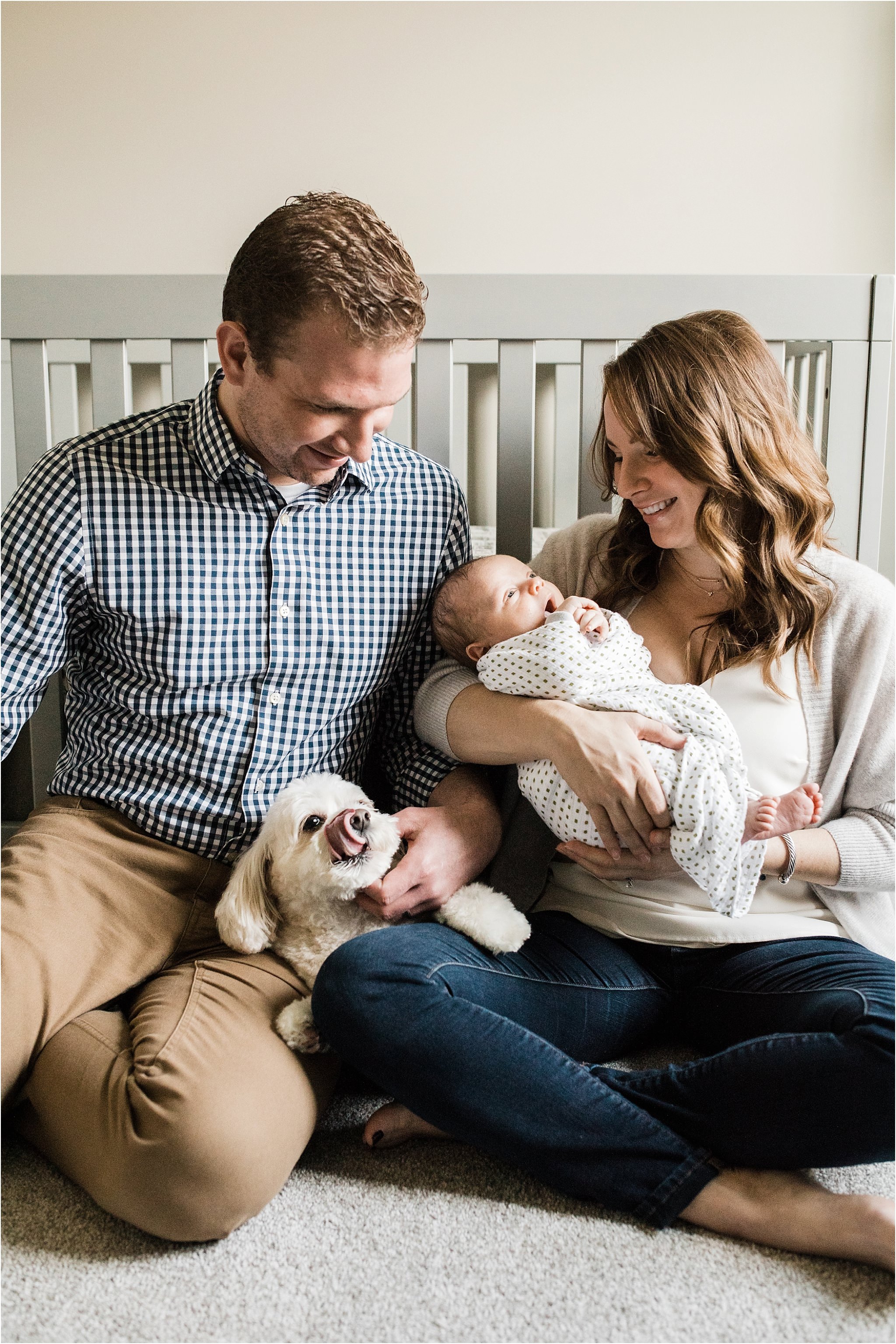 parents holding family dog and newborn baby
