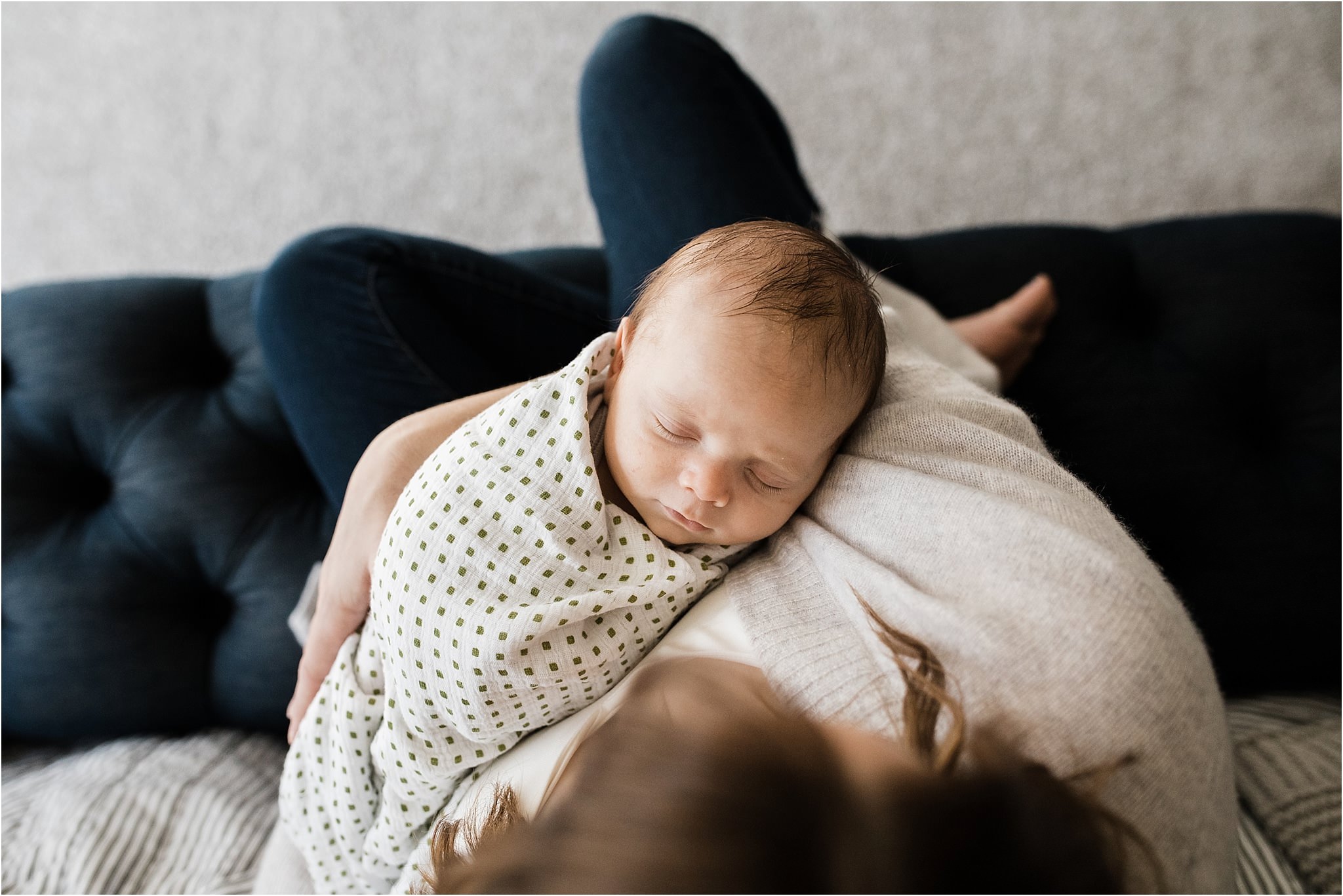 newborn baby sleeping in mothers arms during home newborn shoot