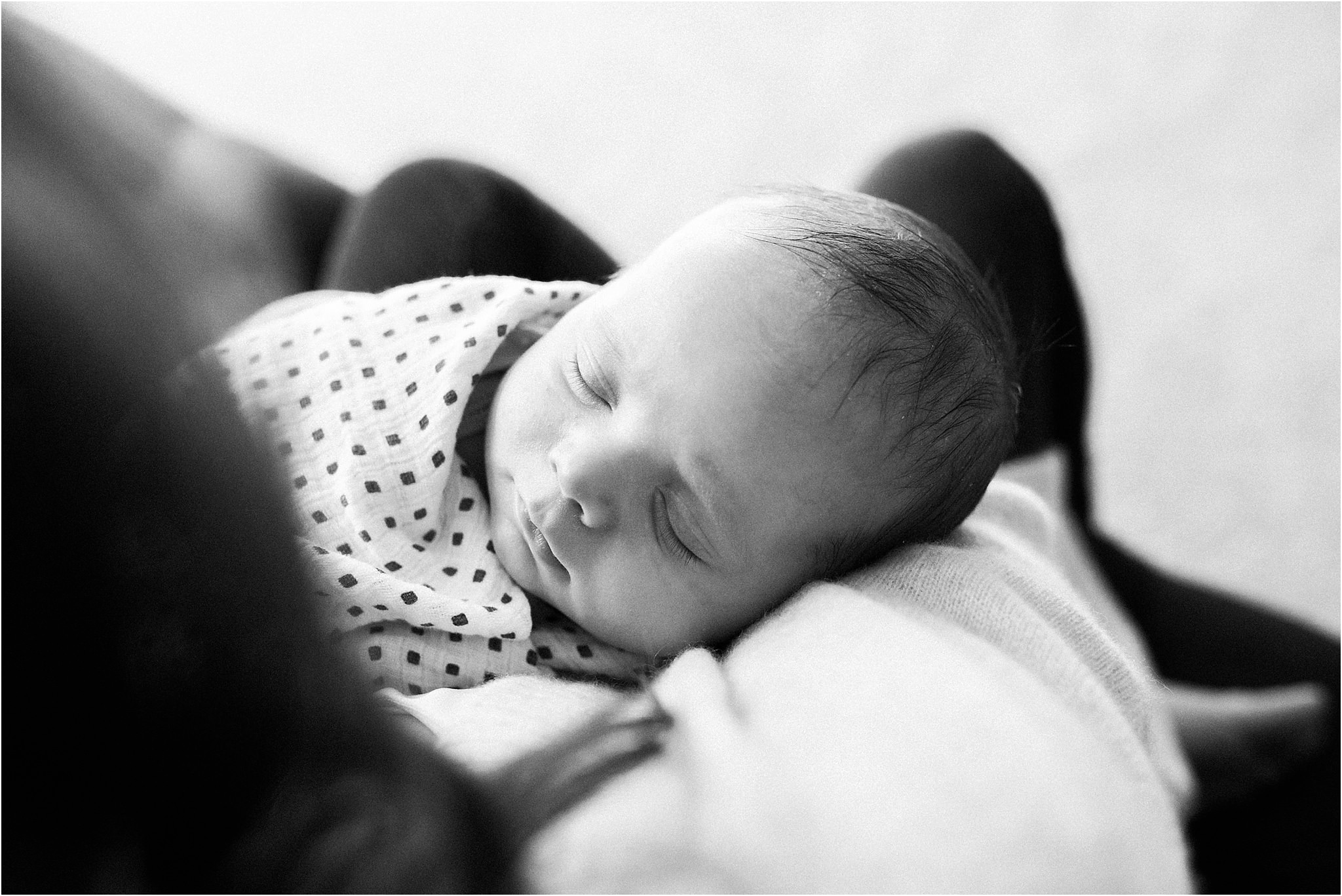 newborn baby sleeping in mothers arms during home newborn shoot