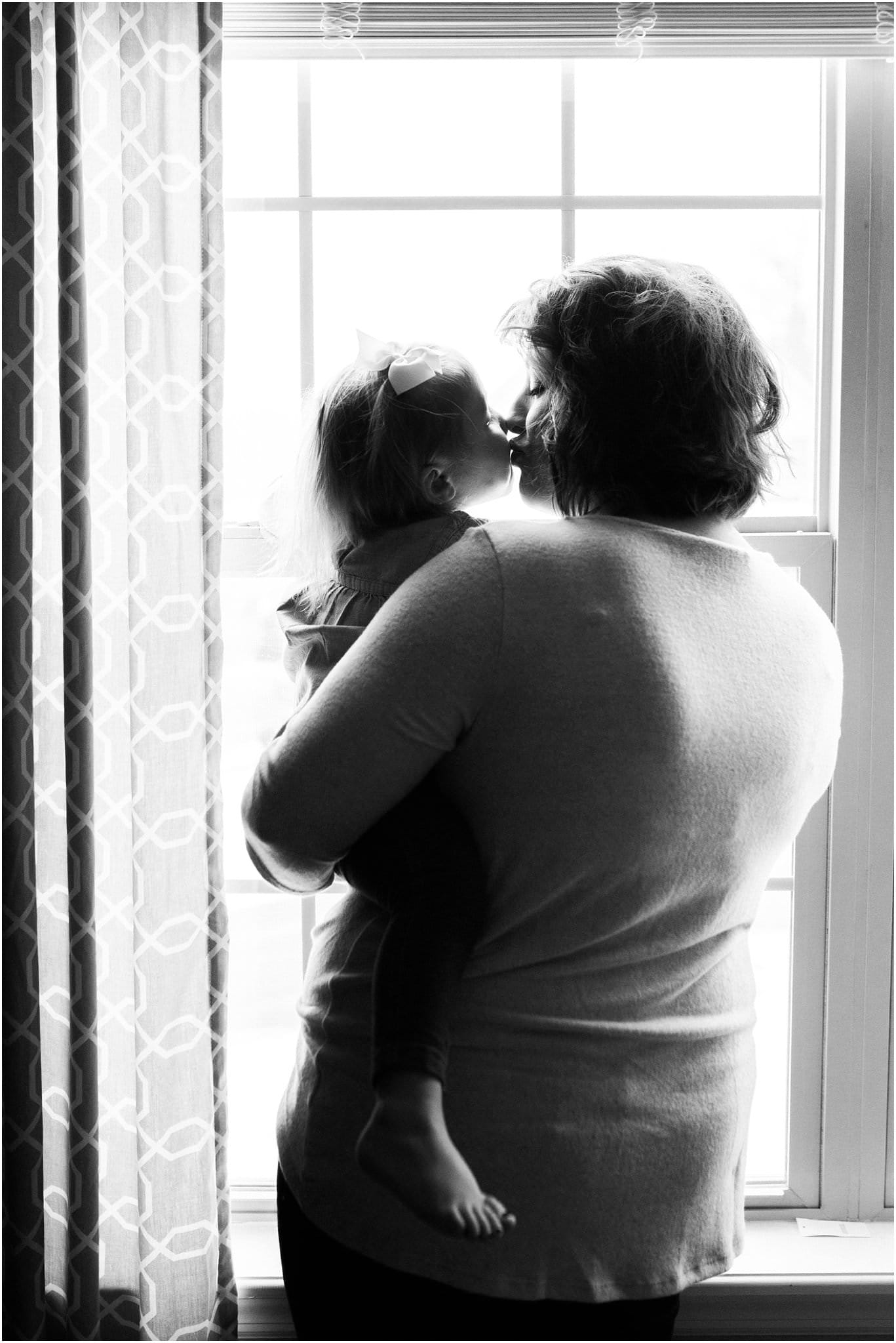 mother holding and kissing daughter